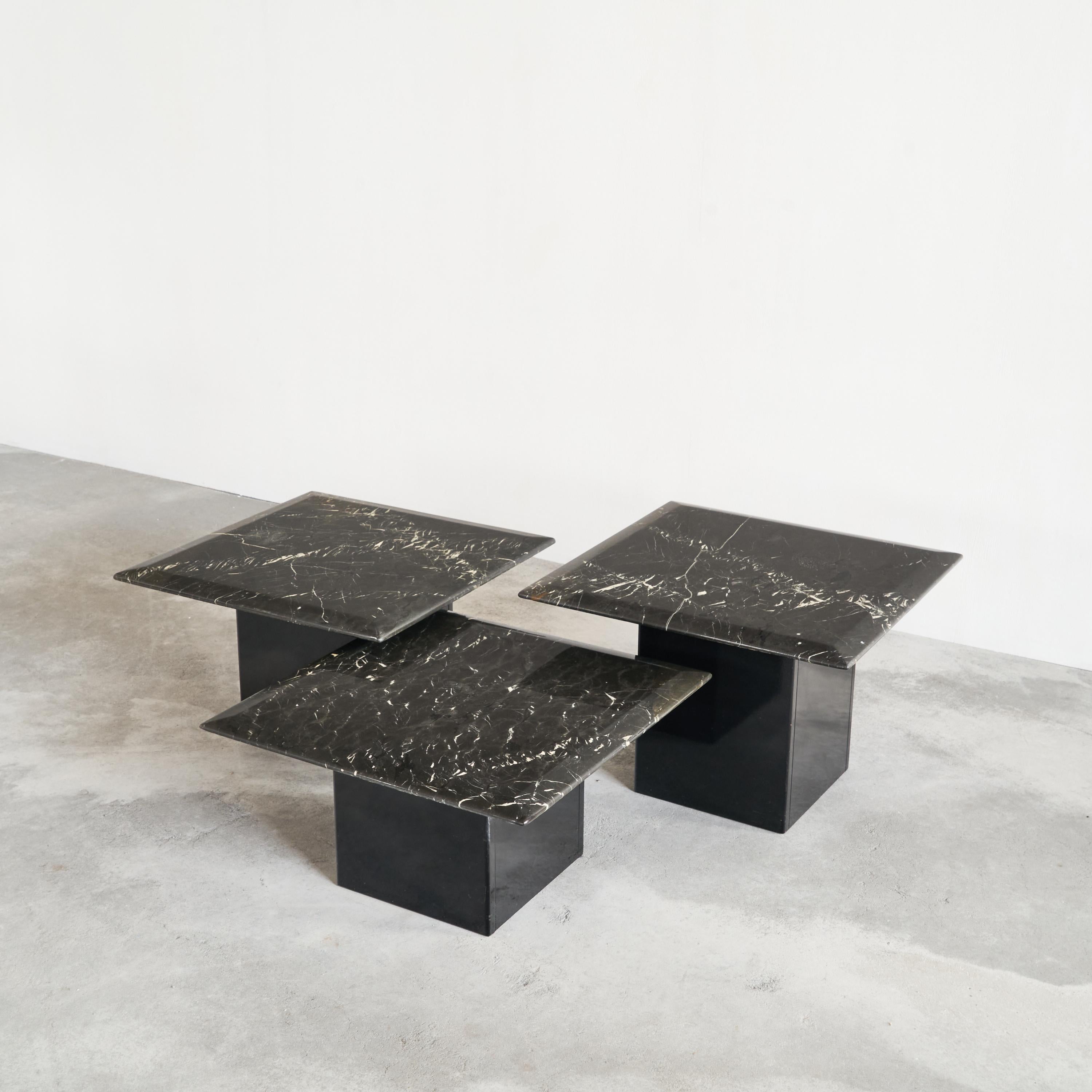 Set of 3 coffee or nesting tables in black marble and black lacquer, 1970s or 1980s.

This is a wonderful set of three coffee, side or nesting tables in expressive black marble with a black lacquered wooden base. They differ in height and