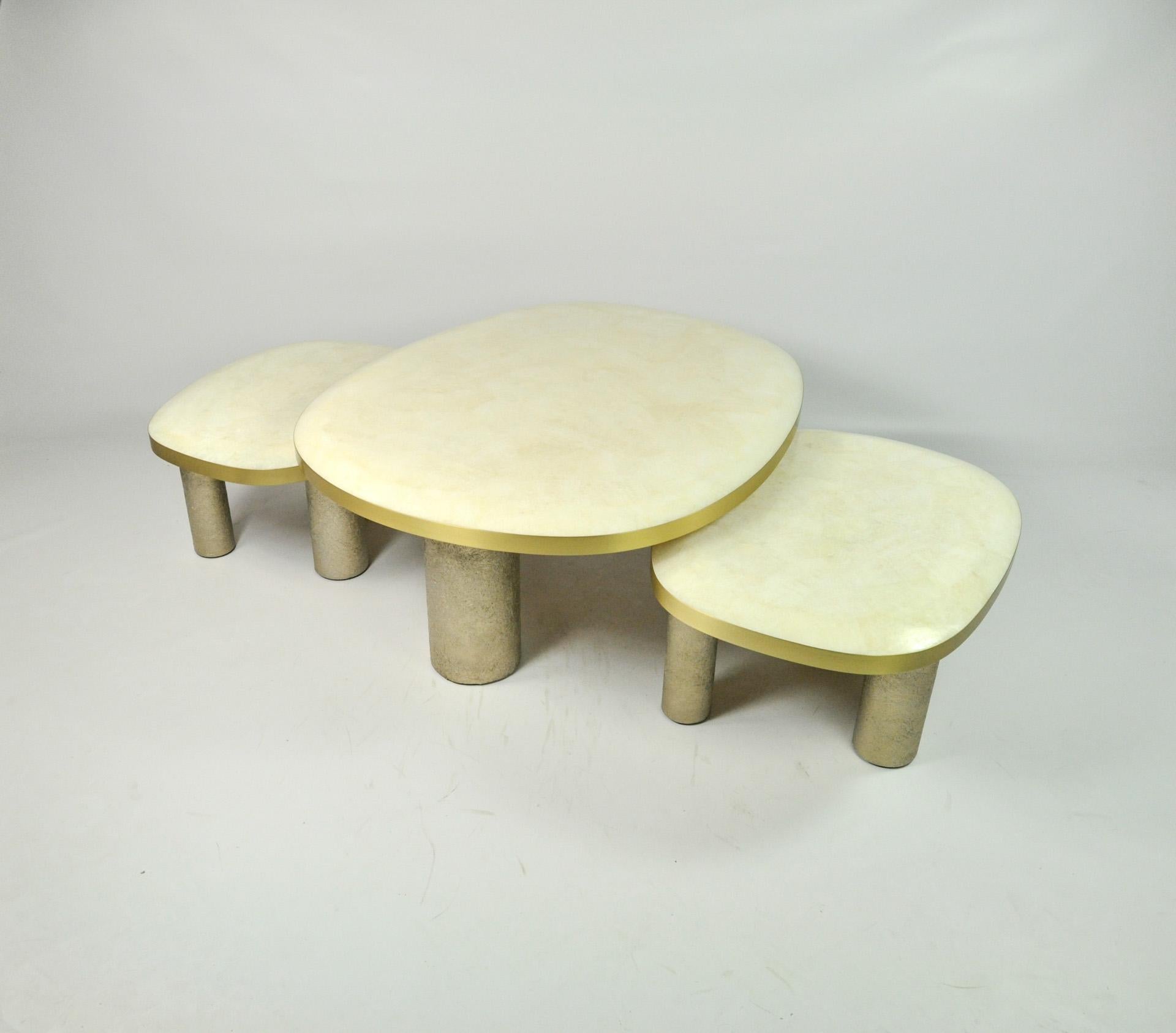 Le set de 3 tables basses Ovoid est composé d'un plateau en marqueterie de cristal de roche blanc.
Les bords du plateau sont en laiton brossé.
Chaque table a trois pieds cylindriques en fibre de verre semi-brut avec une patine dorée.

Le dessus des