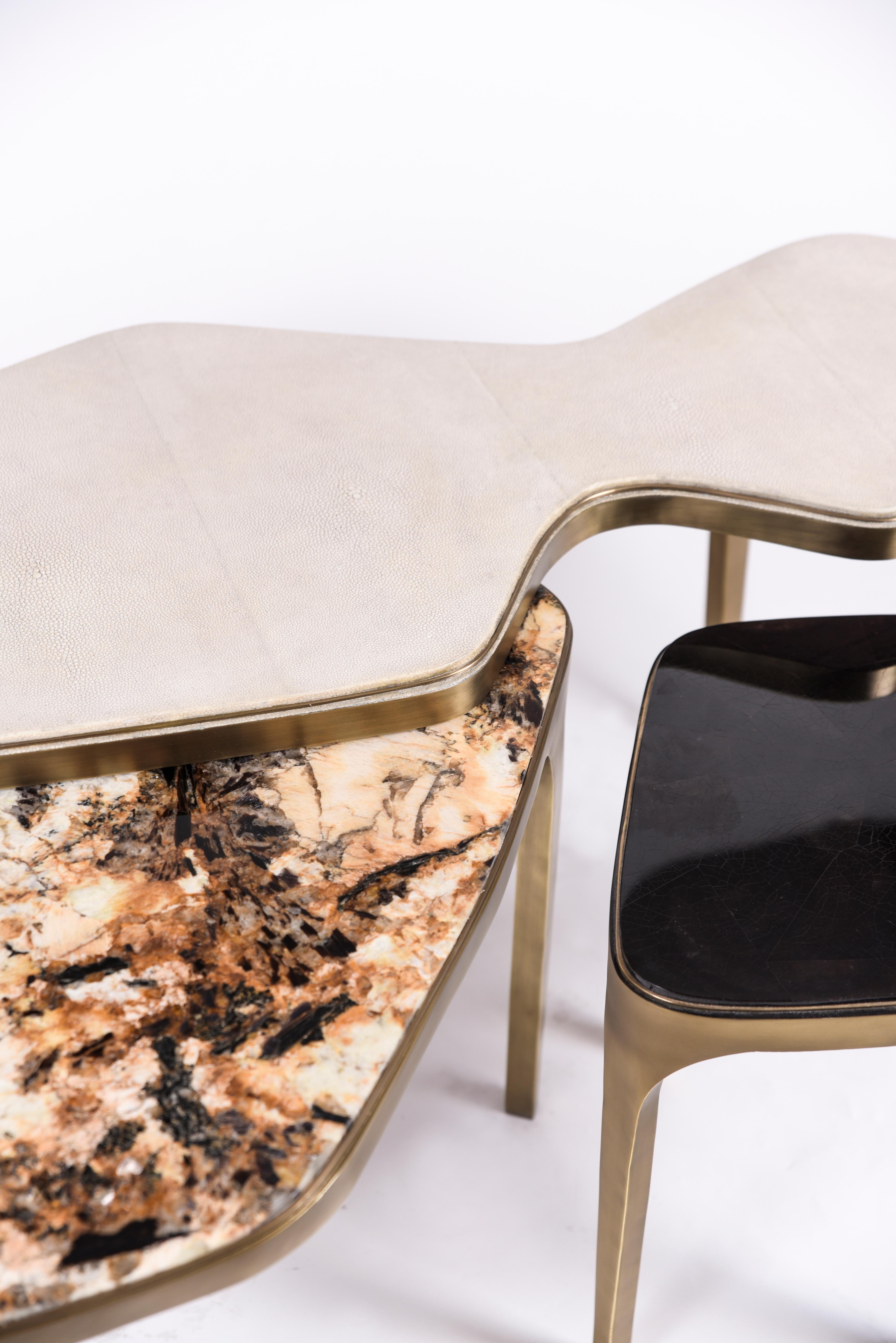 The cosmos nesting coffee tables are both Minimalist and dramatic. The top is inlaid in cream shagreen in the large size, Hwana Stone in the medium size and black pen shell in the small size, that is hand-dyed by artisans, and completed with