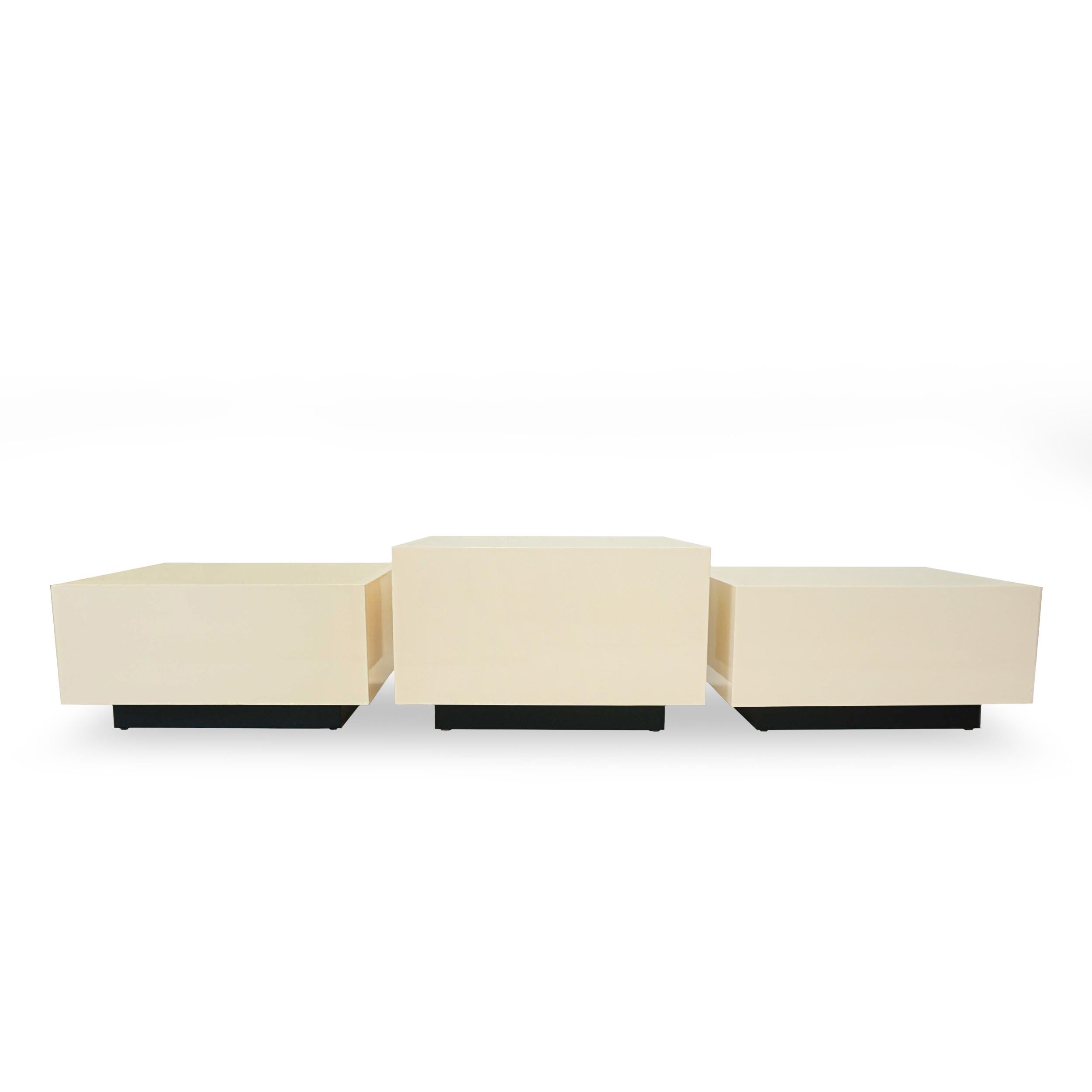 Set of 3 creamy colored lacquered cube cocktail tables built from solid hard maple. Inset top surface color is framed on all sides by a lighter shade of the same hue. Bases of the tables are stained in a dark carbon. Sizes and paint and stain