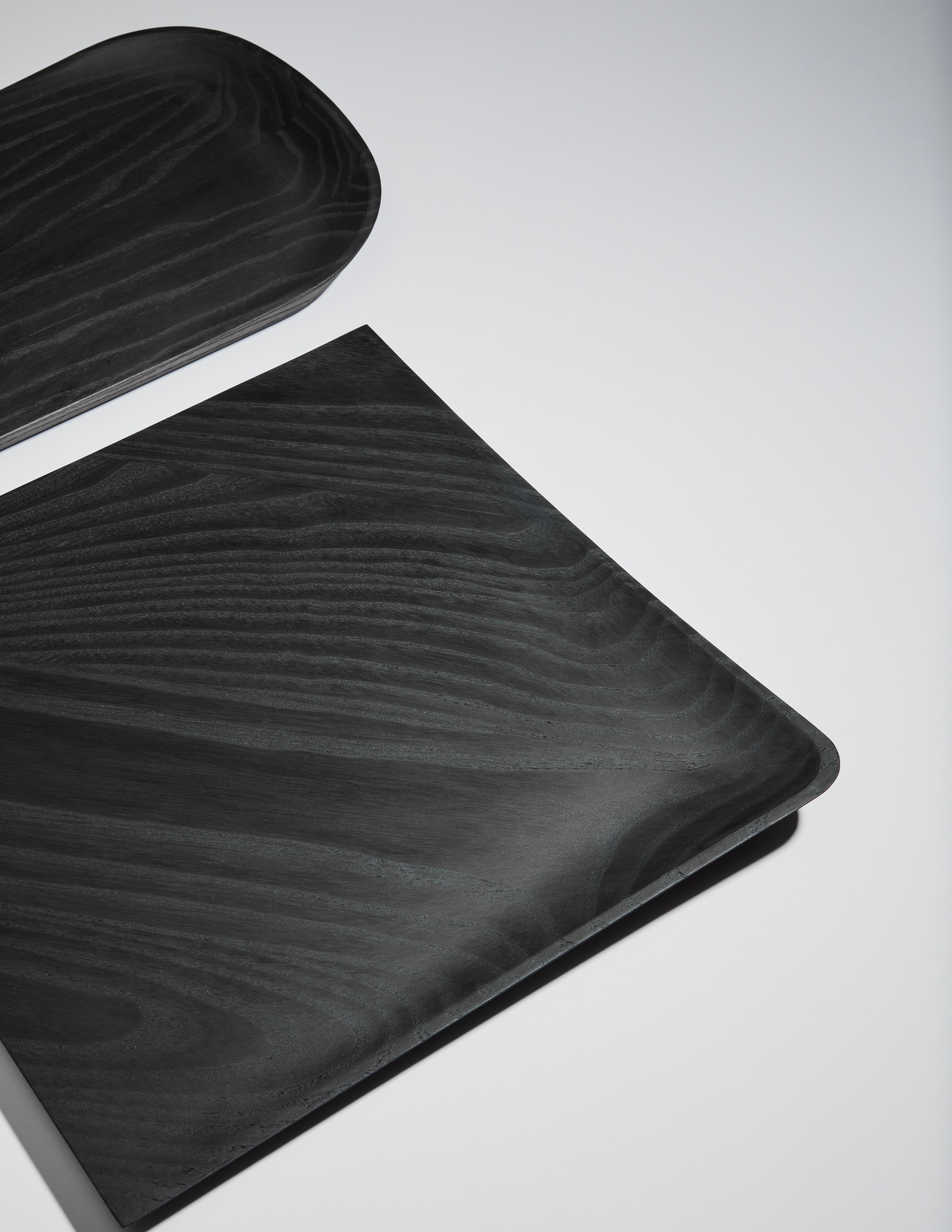 A set of 3 Creux Trays by Clemence Birot
Dimensions: 33 x 32 cm; 39 x 22 cm; 22 x 19,5 cm. 
Materials: ash (black stained).

Clemence Birot started her career in Copenhagen, Denmark, and discovered a design practice closely related to