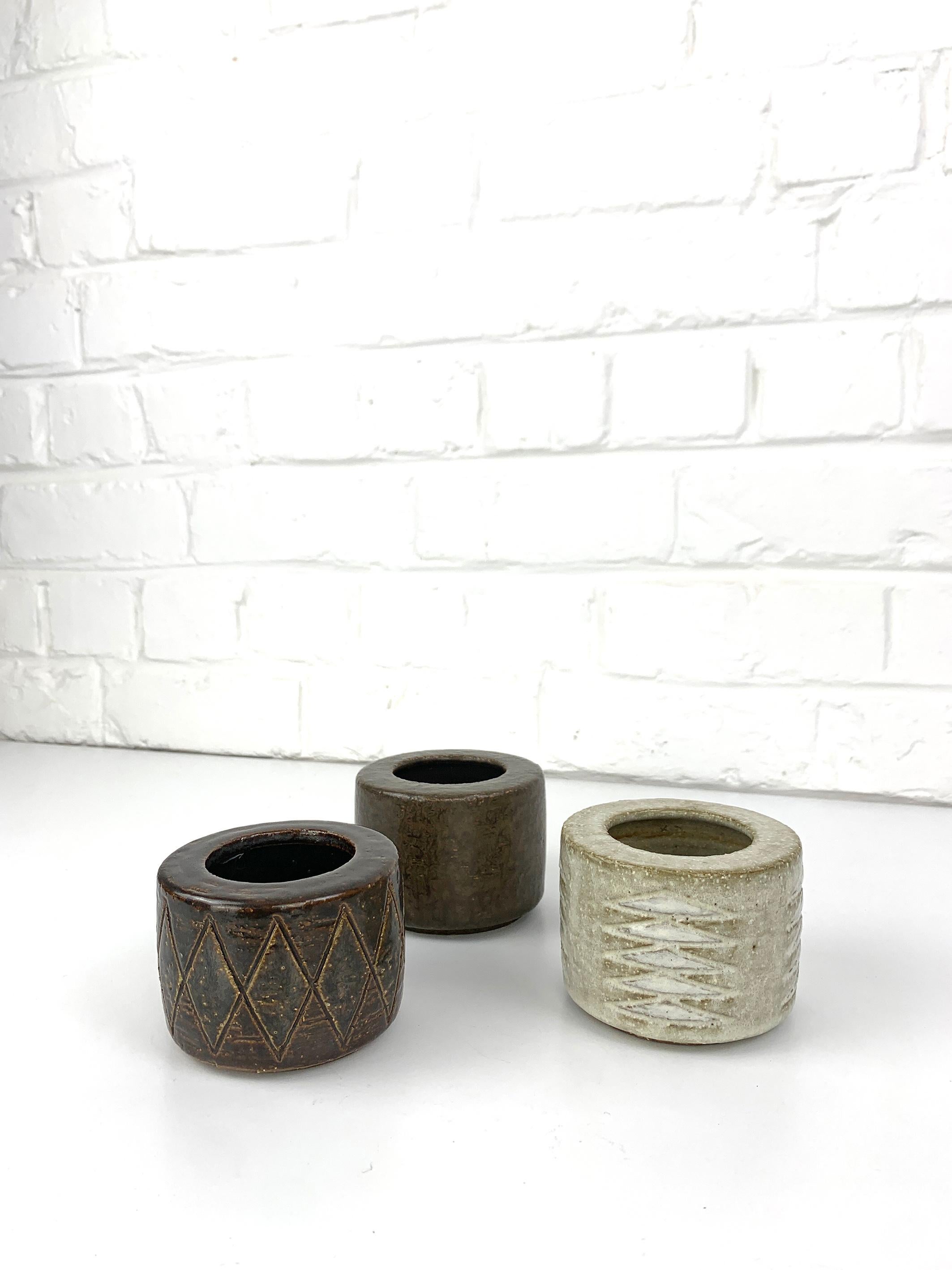 Set of 3 ceramic vases in beige-brown earth tones. They come with a discrete glaze. Scandinavian Mid-Century ceramic. 

Produced in the 1960s by Palshus (Denmark), founded by Per and his wife Annelise Linnemann-Schmidt. The impressed patterns on two