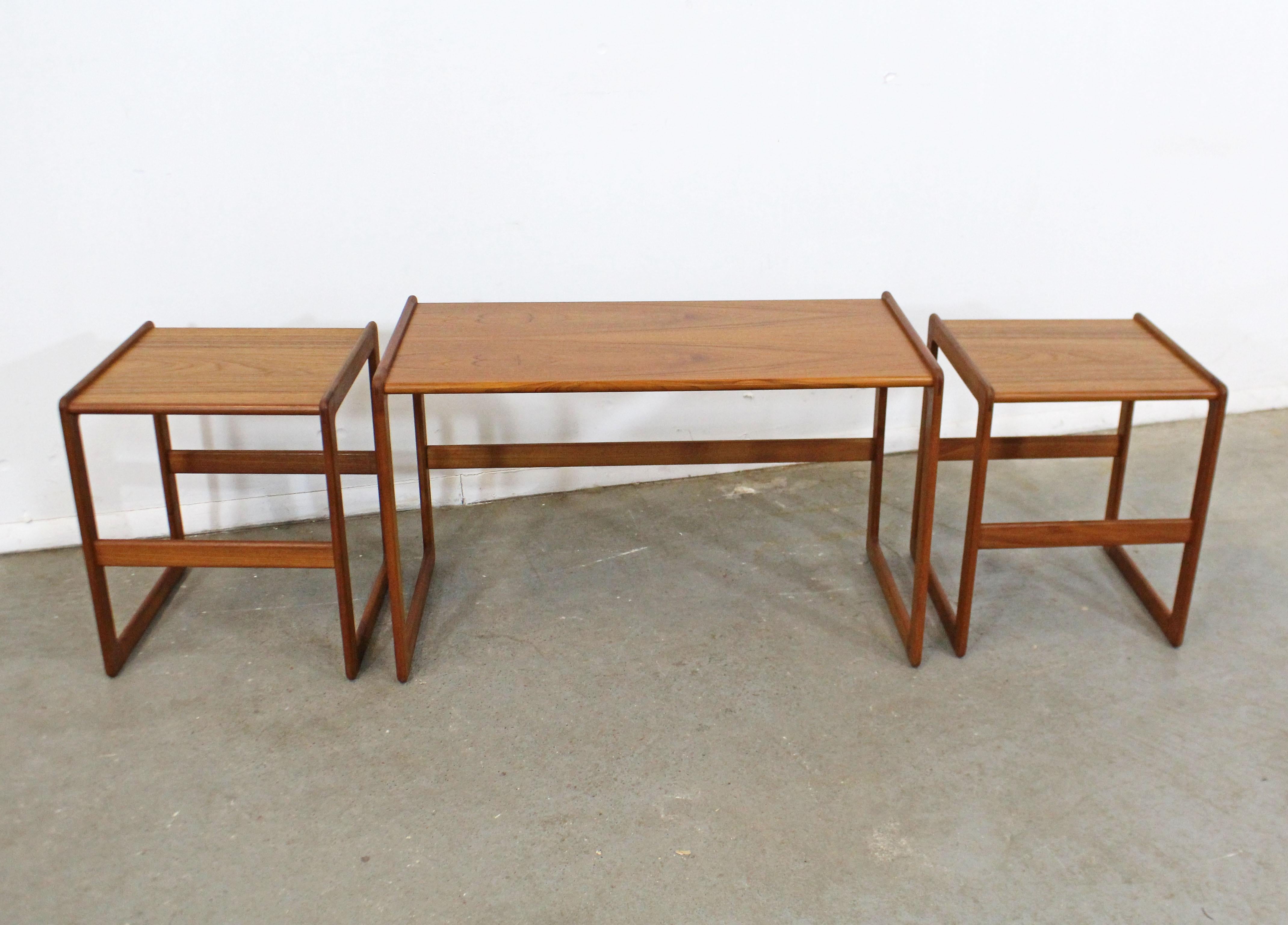 Was für ein Fund. Angeboten wird ein multifunktionaler Satz von 3 modernen dänischen Teakholz-Nesttischen, entworfen von Arne Hovmand-Olsen für Mogens Kold, um 1962. Enthält zwei kleinere Tische, die perfekt unter einen größeren Tisch passen. Sie