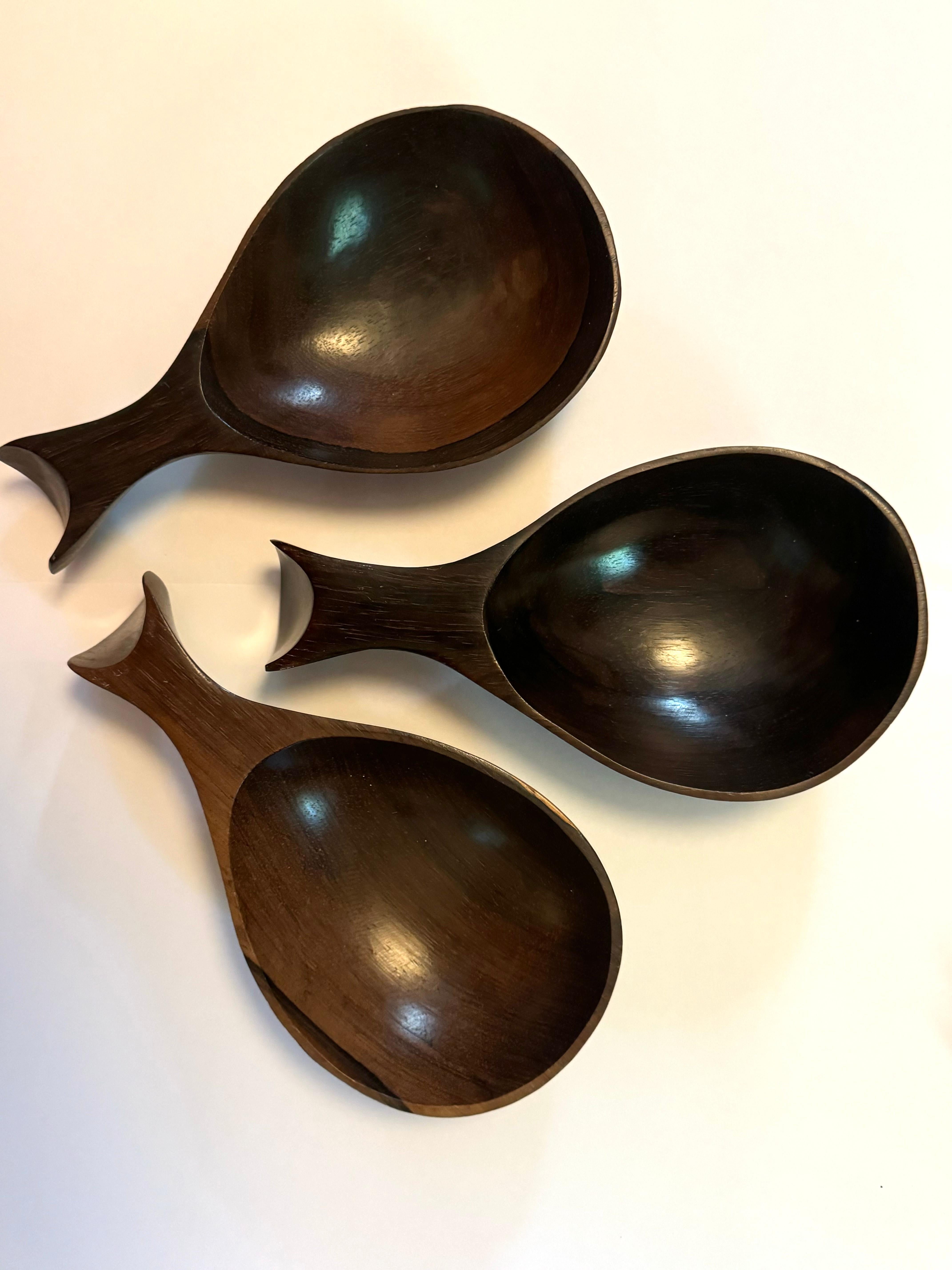 This rare set of three Brazilian wooden bowls from the 1960s exemplifies the elegance of mid-century modern craftsmanship. Carved from rich, dark wood, each bowl features a unique, organic shape with smooth curves and a beautiful natural grain,