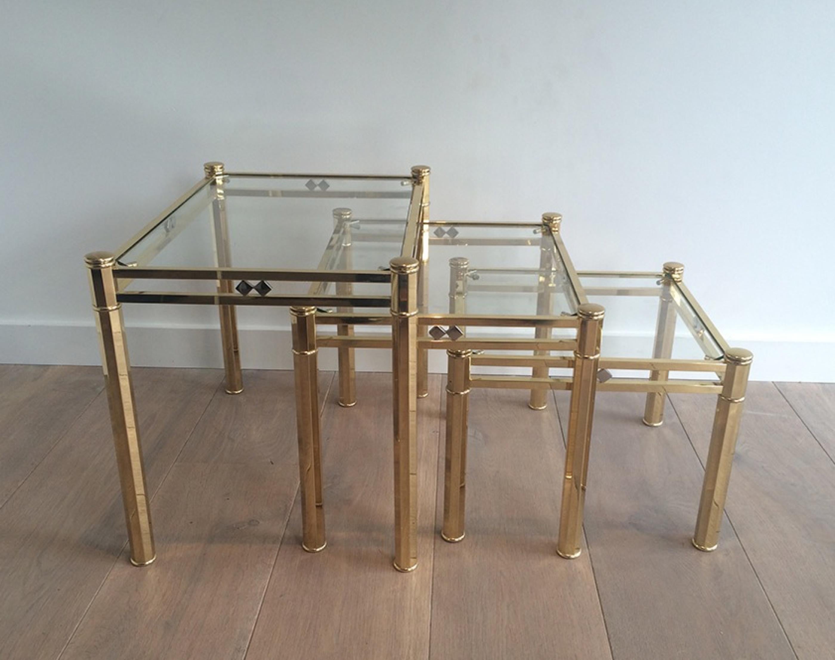 This very nice set of 3 decorative nesting tables is made of brass with clear glass shelves. This is a French work of very good quality, circa 1970.