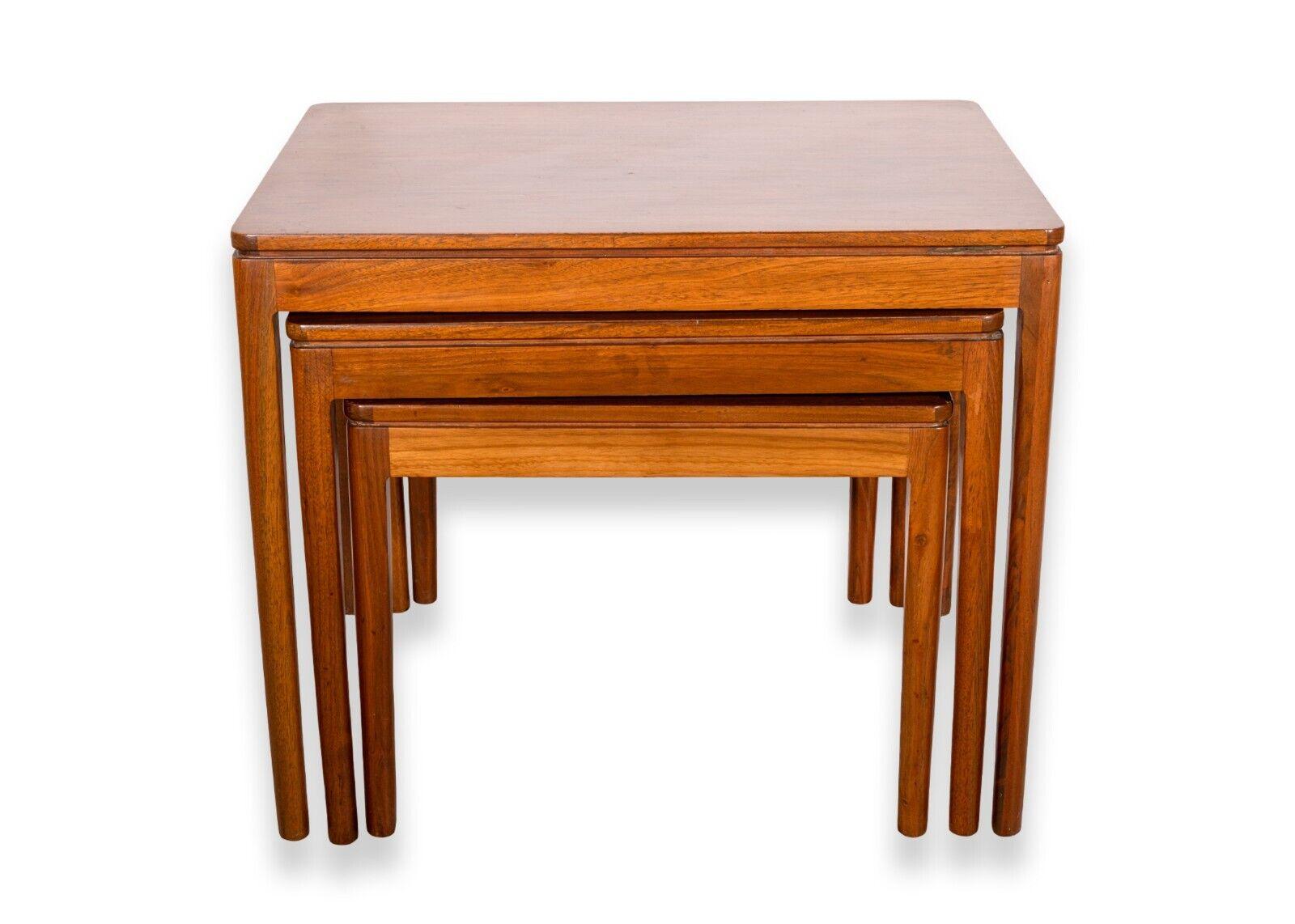 A set of 3 Drexel Declaration mid century modern walnut wood nesting side end tables. A wonderful set of nesting tables featuring a rich walnut wood construction. These tables feature a simple mid century modern design with rounded legs and a