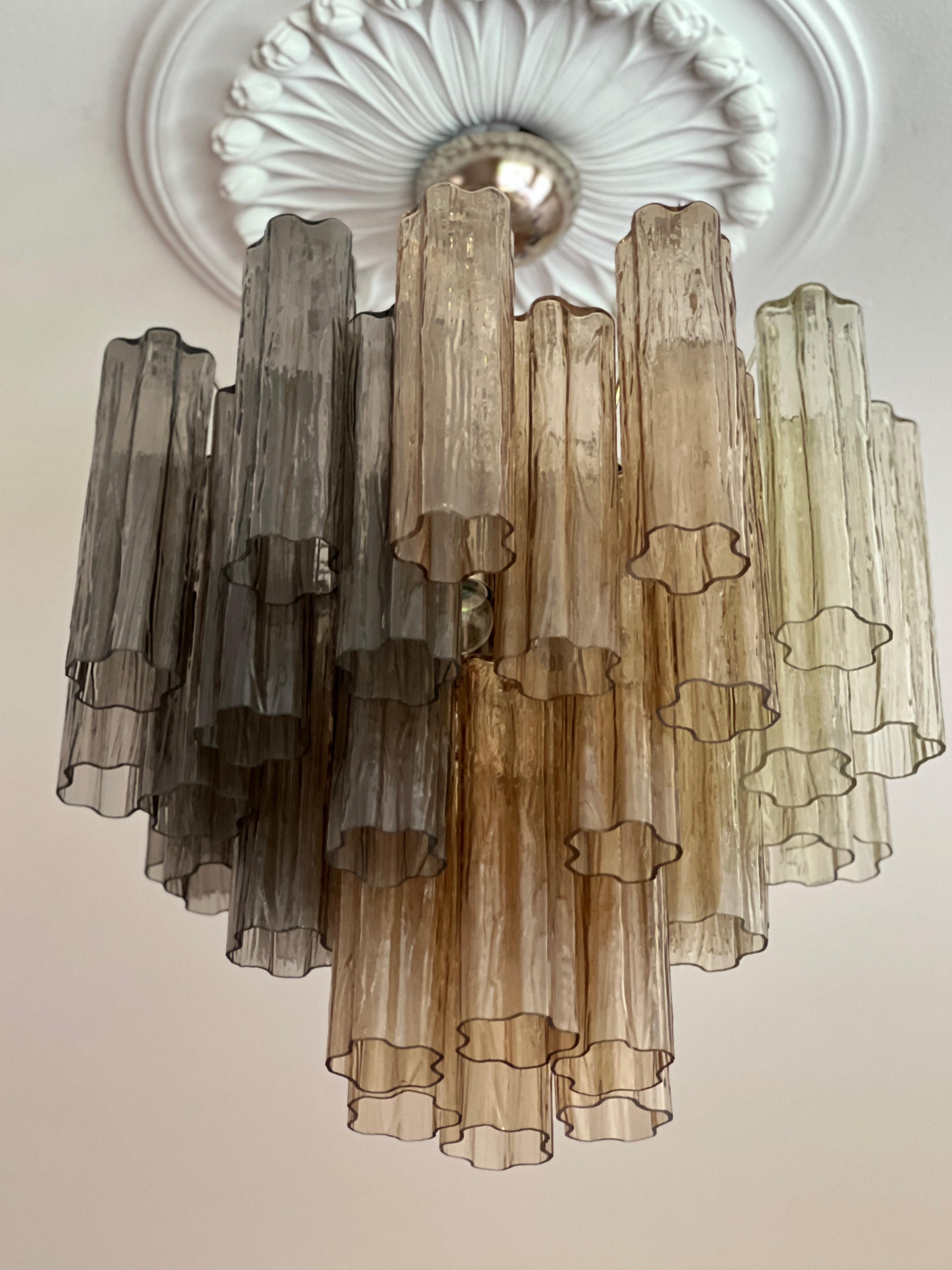 Multi-Colored Contemporary Murano Lamp in ombre. Glass prisms in honey, sand and smoked grey tones. Tubular Tronchi Formed Glass Prisms in Traditional Italian Mid-Century Style.
The murano fixture is composed of 36 Glass Elements in the size of 25