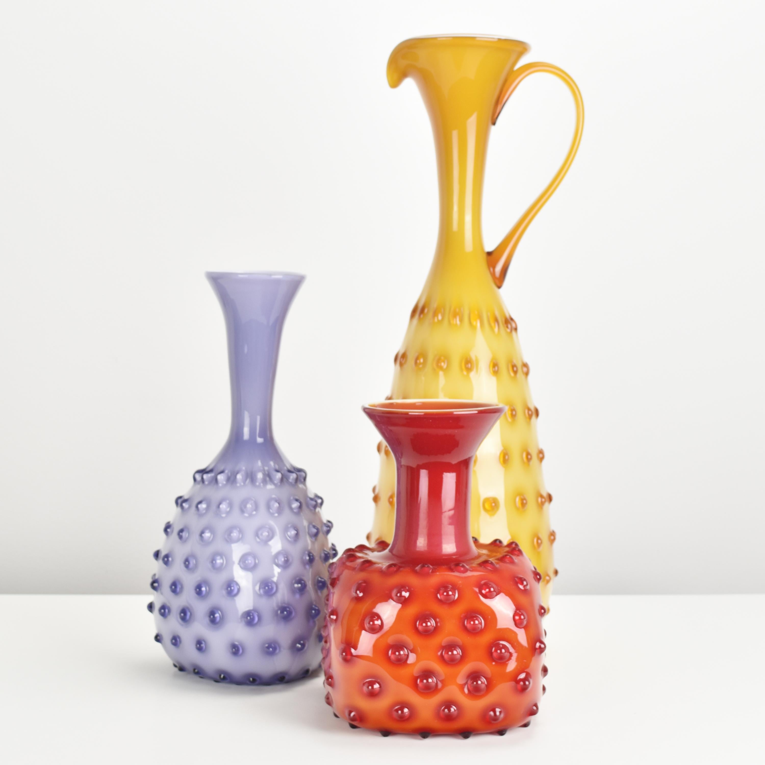 The set of three different Empoli vases with a hobnail pattern showcases the charm and craftsmanship of mid-century Italian glassmaking. Empoli is a region in Tuscany, Italy, renowned for its long tradition of producing high-quality glassware.

Each