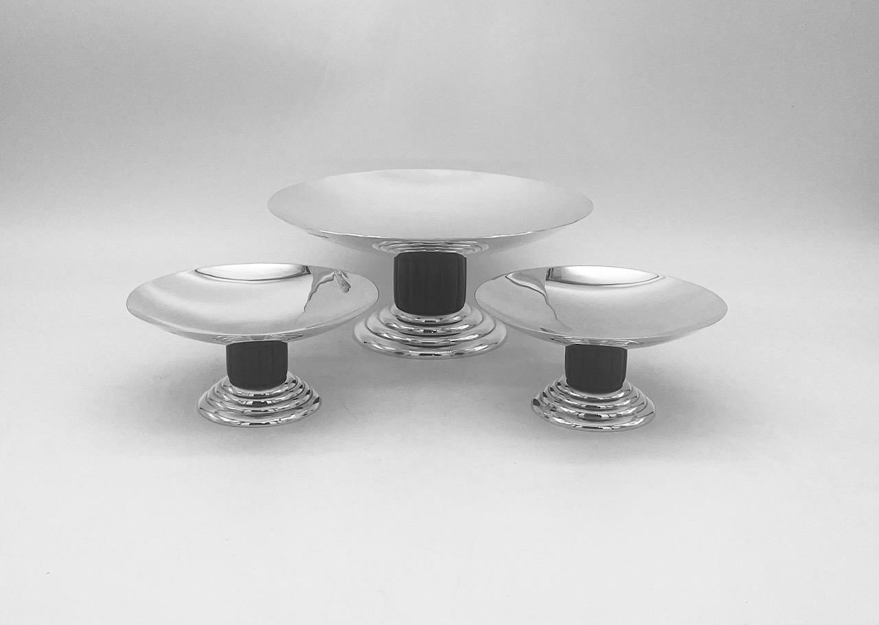 A set of three sterling silver Art Deco Comports, made by the English firm of Elkington & Co. hallmarked in Birmingham 1936, and designed by one of the foremost designers of Art Deco silver, Jean E. Puiforcat. 
This set comprises one large dish