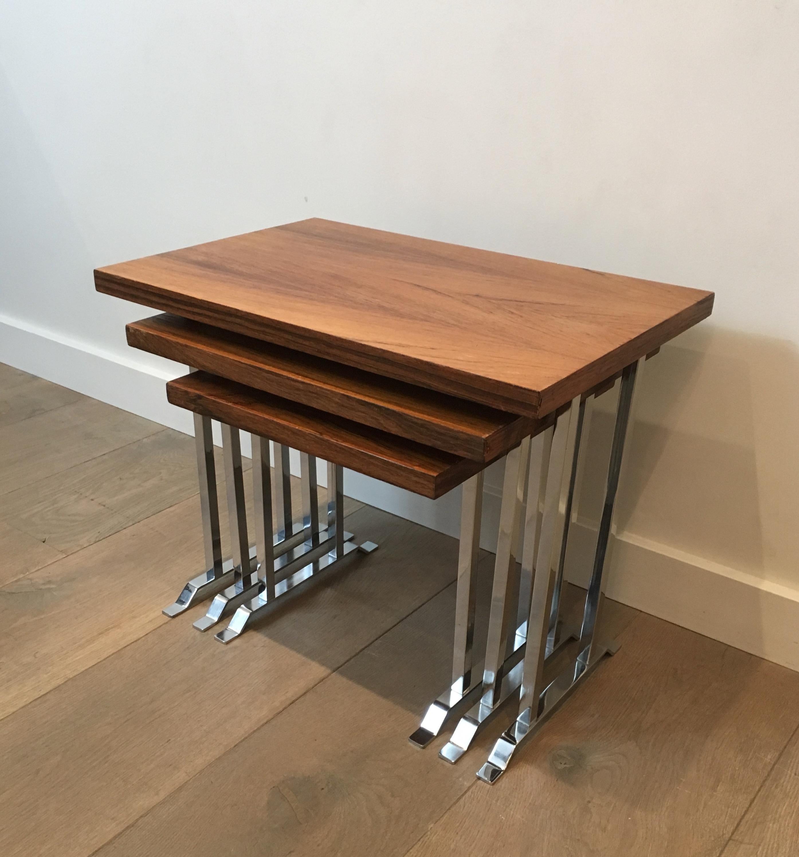 This set of 3 nesting tables is made of exotic wood tops on chrome bases. This is a French work, circa 1970.