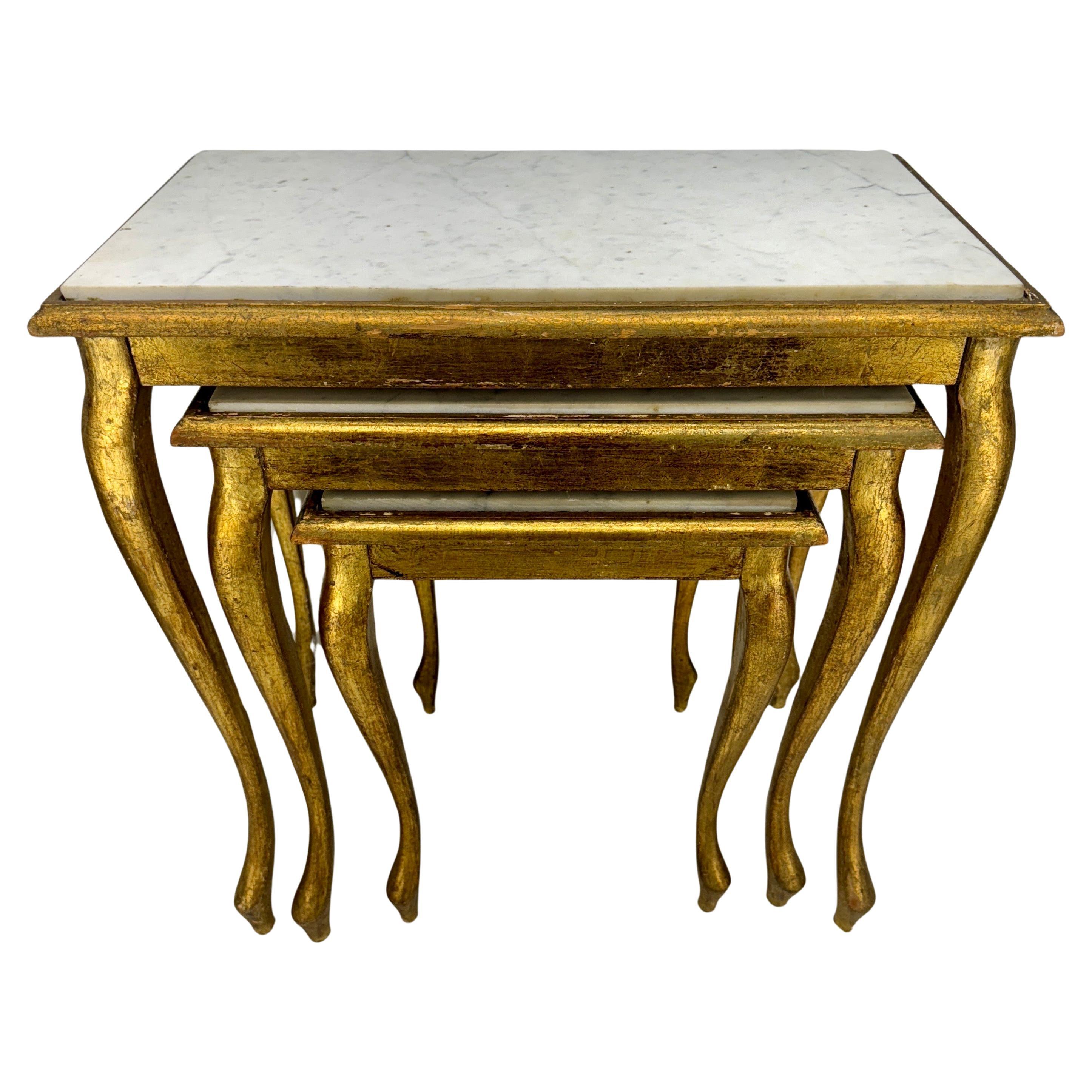 Ensemble italien de trois tables gigognes en bois doré Florentine à plateau de marbre blanc, vers 1950.
Les tables sont présentées dans leur état d'origine et ont conservé leur belle patine vieillie par les intempéries. Les trois tables serviront de