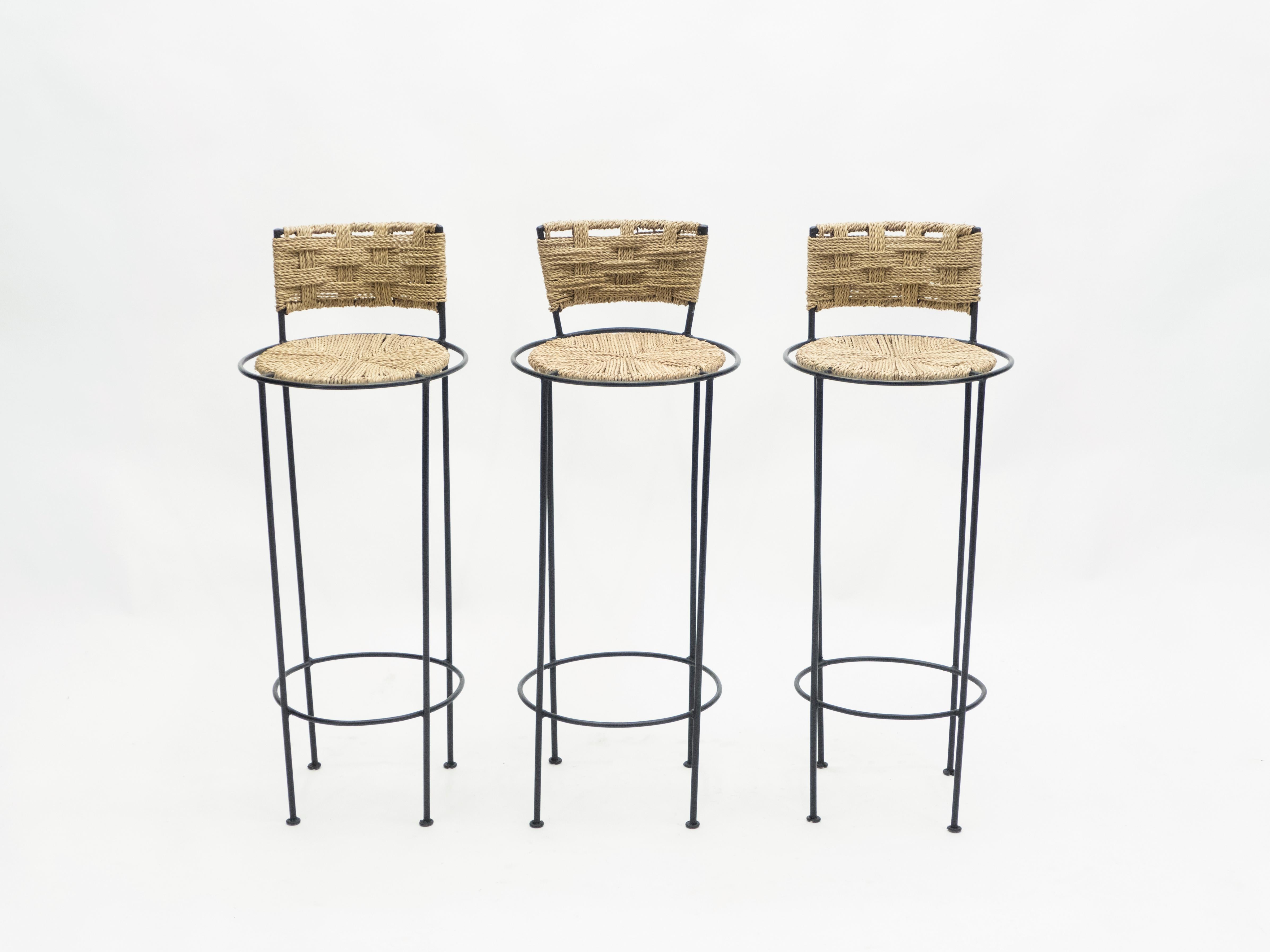Beautiful patina is evident along the abaca rope seating and backrest of this set of three bar stools by Adrien Audoux et Frida Minet, giving away their vintage status. This natural style is typical of the French design of Audoux-Minet. Timeless