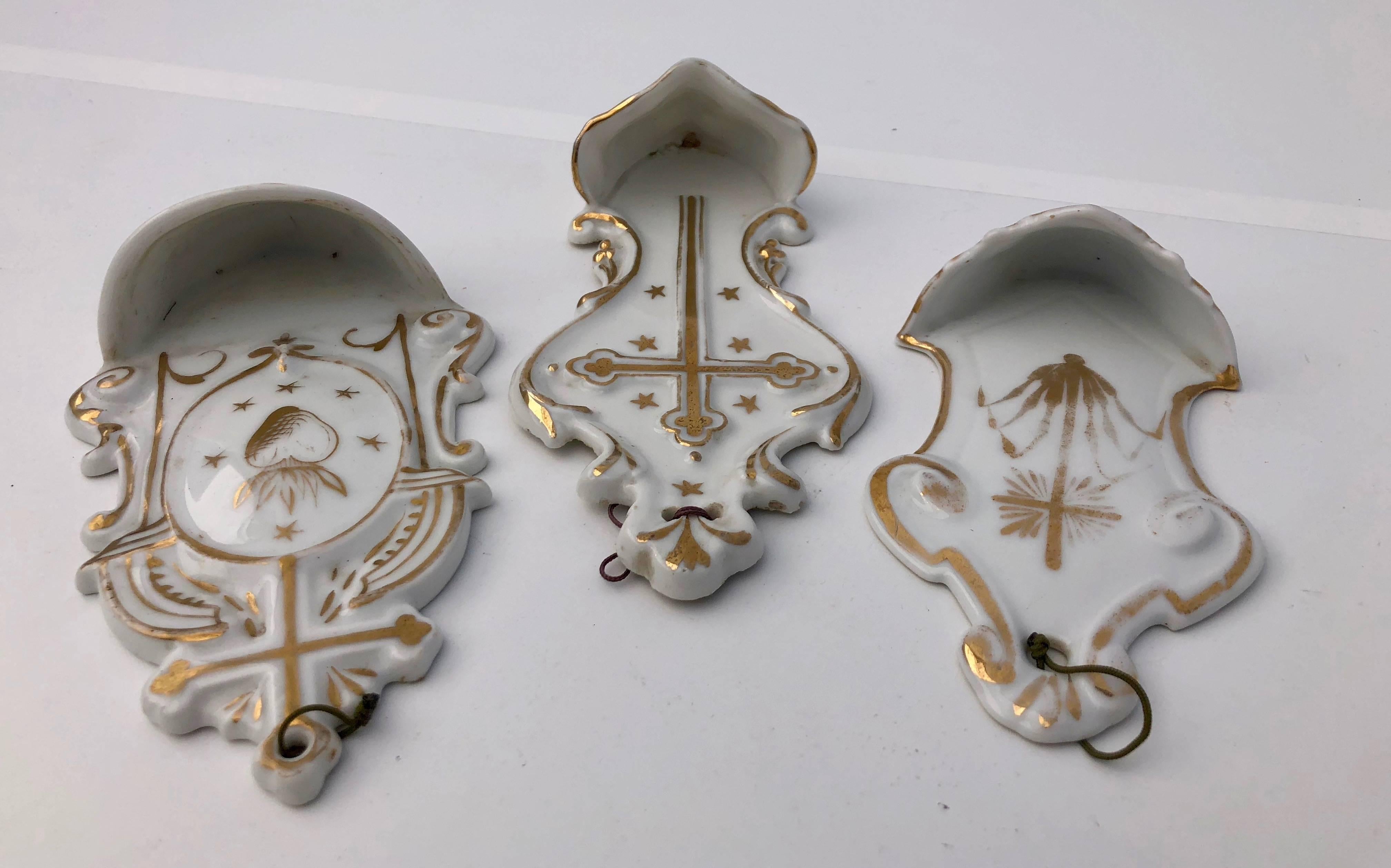 This beautiful collection of French antique holy water fonts (bénitiers) are white with elaborate gold trim and gold crosses. They are all Porcelaine de Paris from the early 1900s. Displayed as a collection they make a stunning