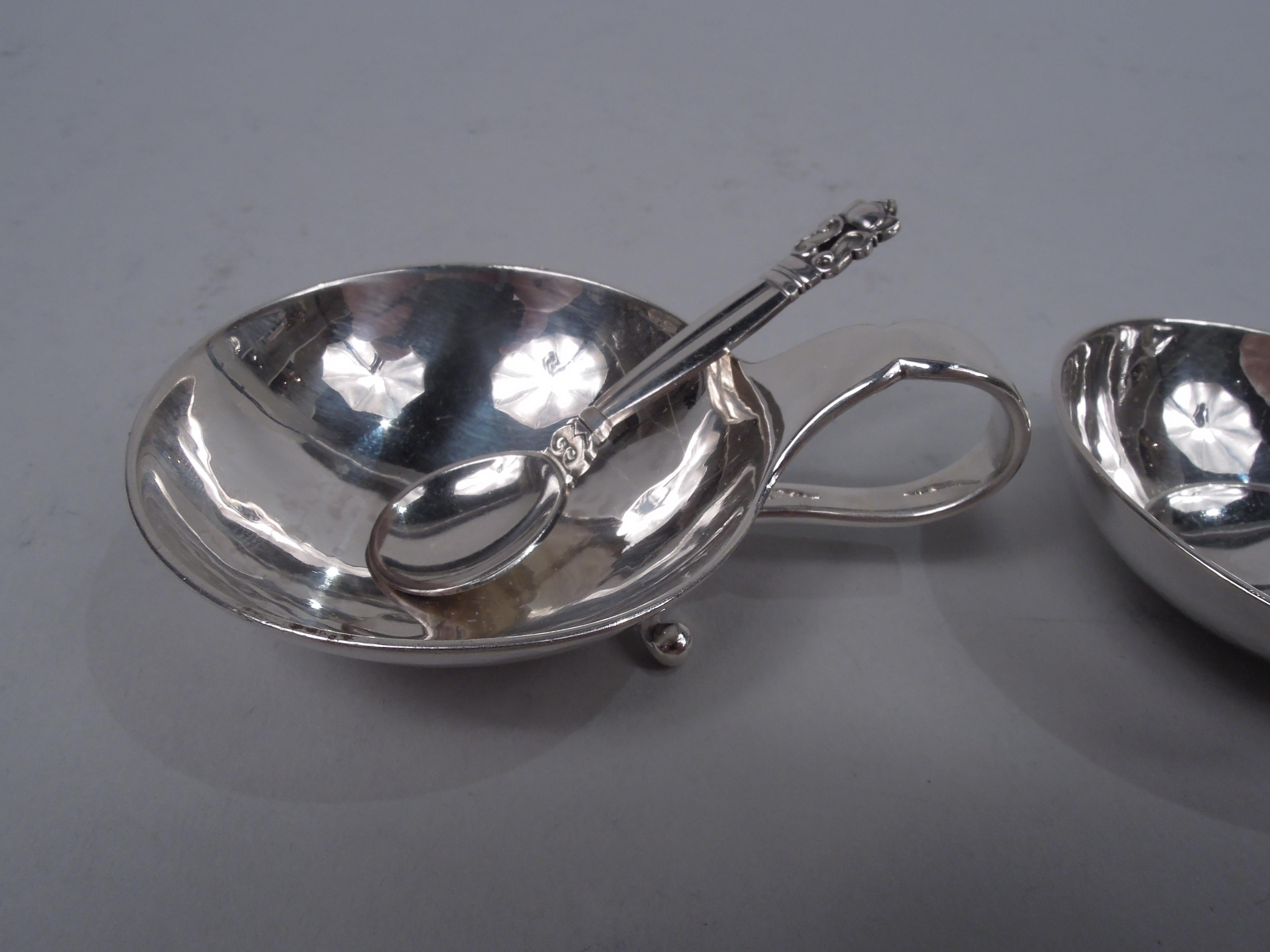 Set of 3 Modern sterling silver open salts. Made by Georg Jensen in Copenhagen. Each: Curved and shallow bowl with tapering and high-looping split-mounted handle with bead terminals. Fully marked including maker’s stamp and no. 110. Two have postwar