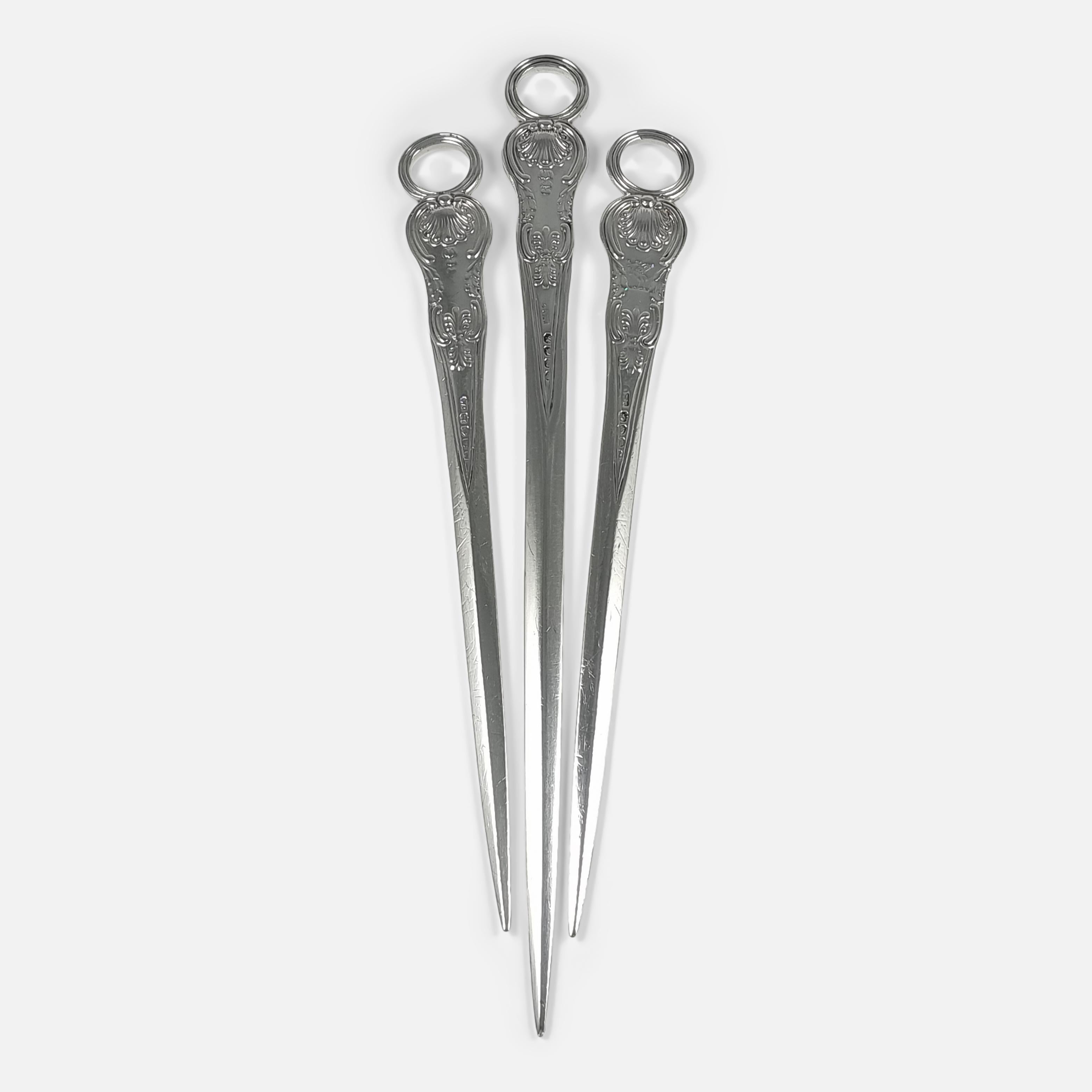 A set of three George III silver Kings pattern meat skewers made by the English Silversmith William Chawner II in 1819. The graduating meat skewers are decorated in the Kings pattern, with engraved family crest, and completed with a ring loop