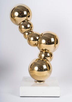 Conjunto de 3 esculturas de metal dorado con bases de mármol, del siglo XXI.