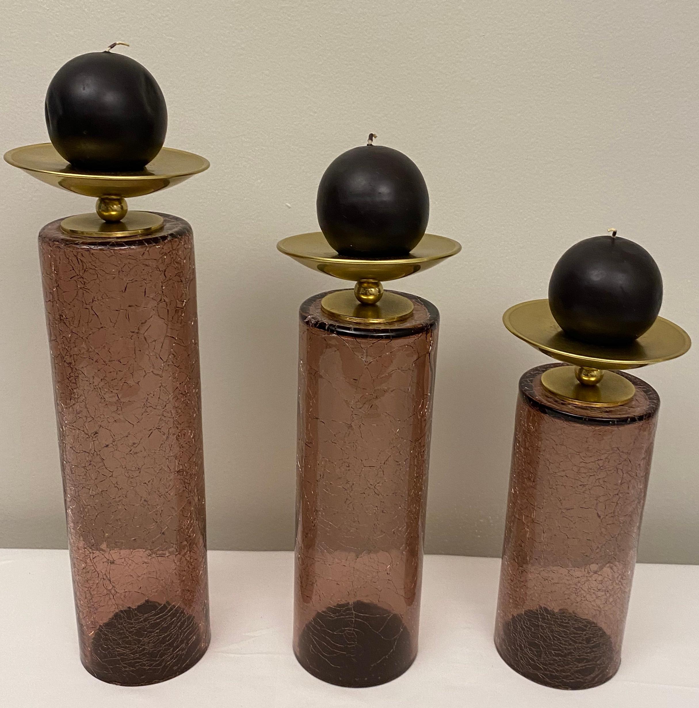Striking set of 3 staggered candle holders, vintage American modernist glass and brass, circa 1970-79. These interestingly designed candle holders are in remarkable vintage condition. 

Dimensions with candles: 
Smallest candle holder: 12 1/4