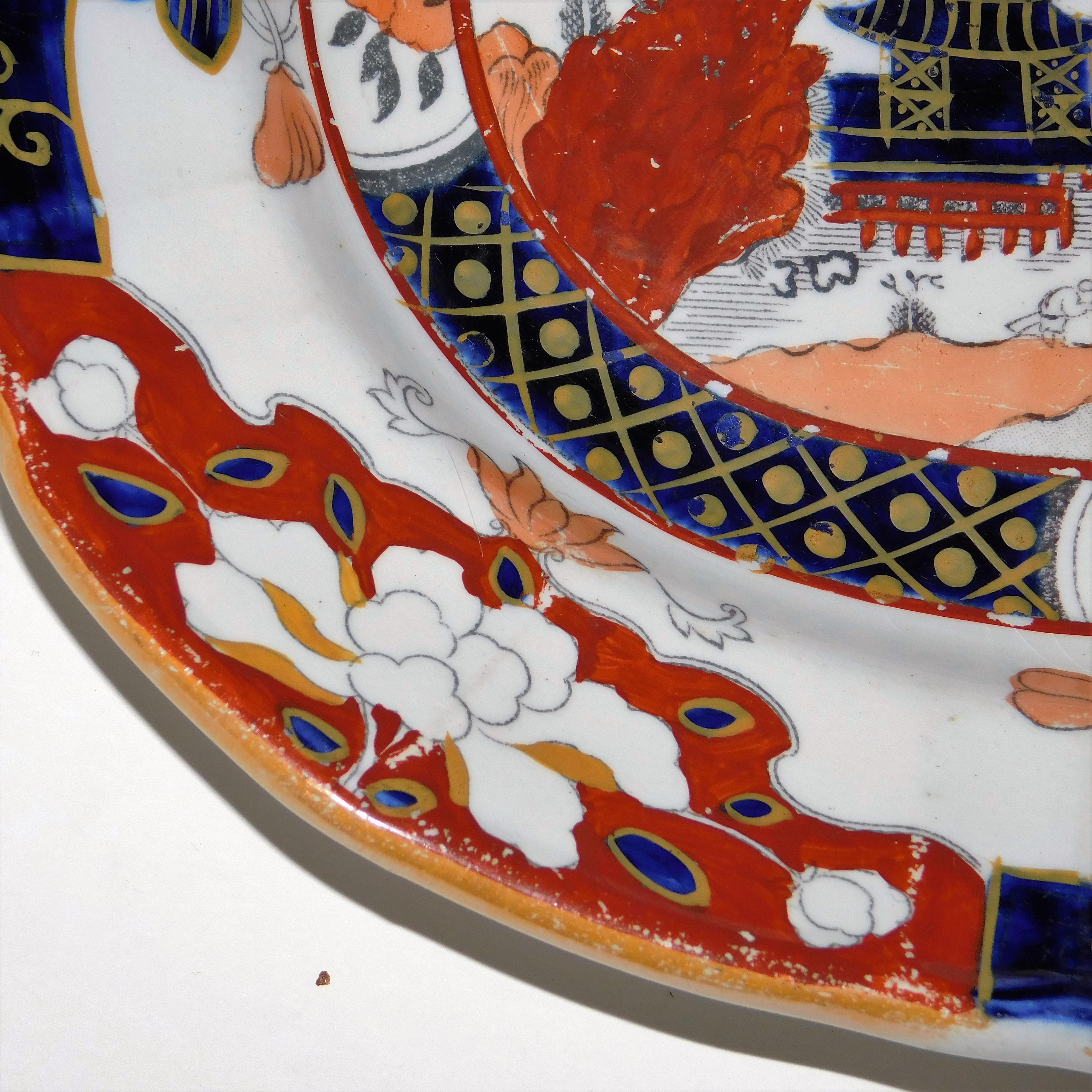 Design in the oriental taste based on Chinese export designs in rich colors of navy dark red and salmon on a white ground, printed and impressed marks on back, polychrome decoration, ironstone. Measurements below are for the largest platter; others