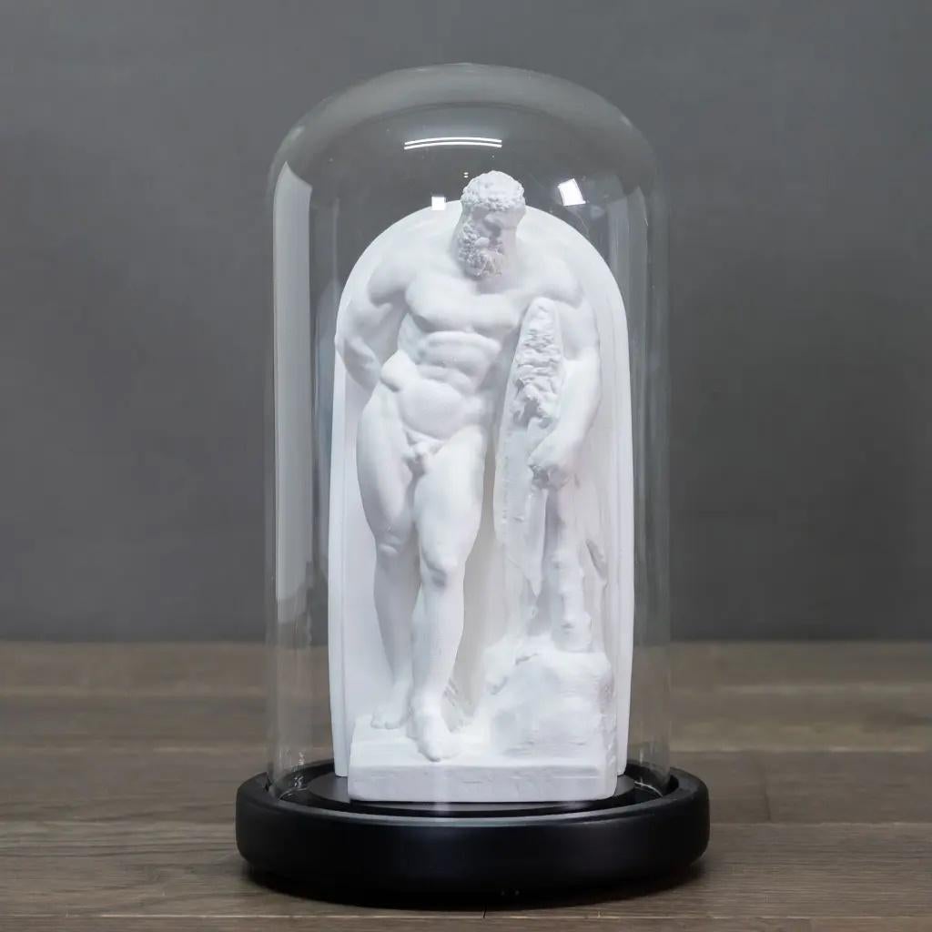 This set of 3 Greek figures is presented in elegant glass globes, highlighting each sculpture. Made in immaculate white plaster, these pieces evoke the purity and finesse of ancient marble, offering a faithful rendering of the masterpieces of