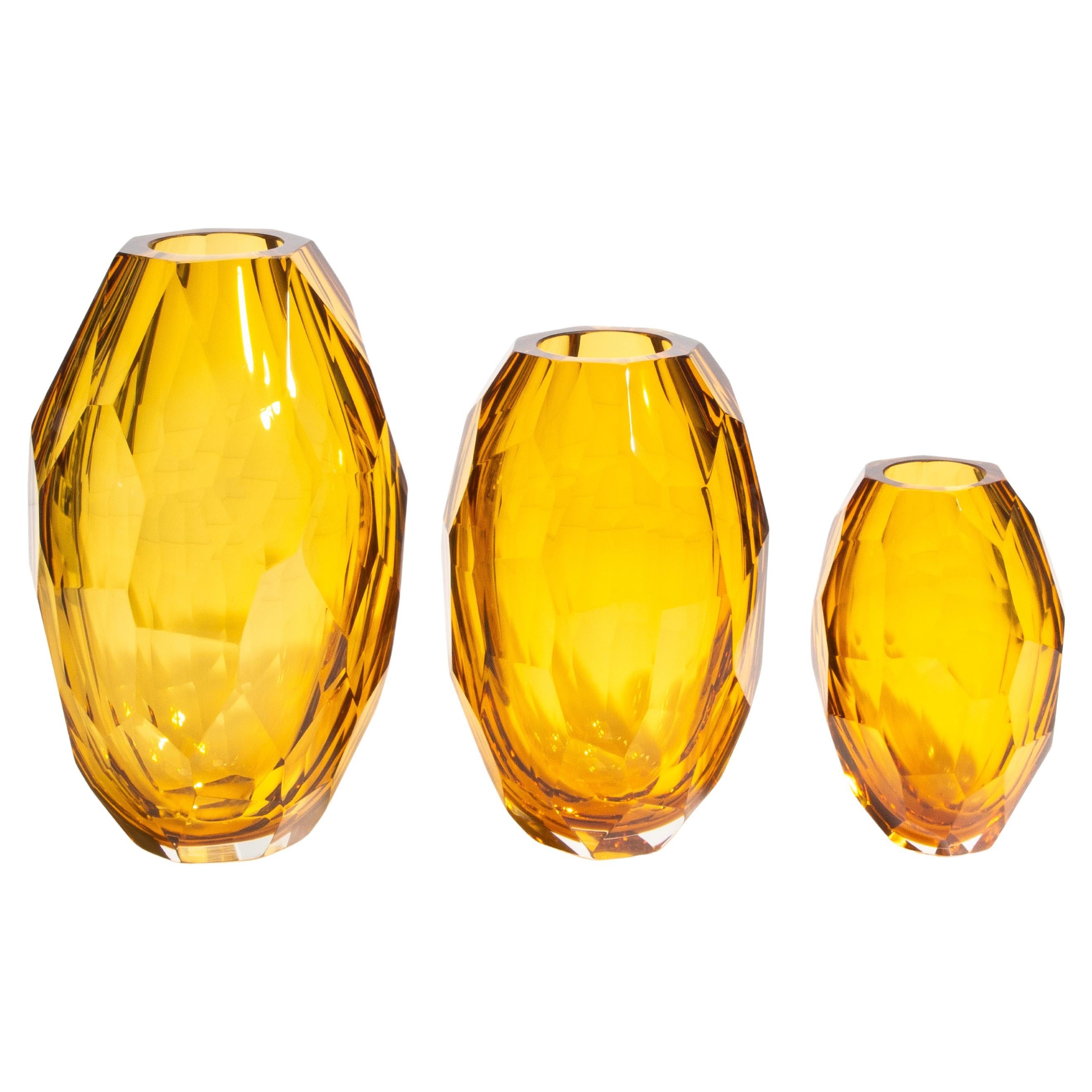 Elevate your home décor with the sublime elegance of our faceted amber vases, a masterpiece of Murano glass artistry. This exquisite trio, meticulously crafted by skilled artisans, captures the essence of timeless luxury. The rich, golden amber hue