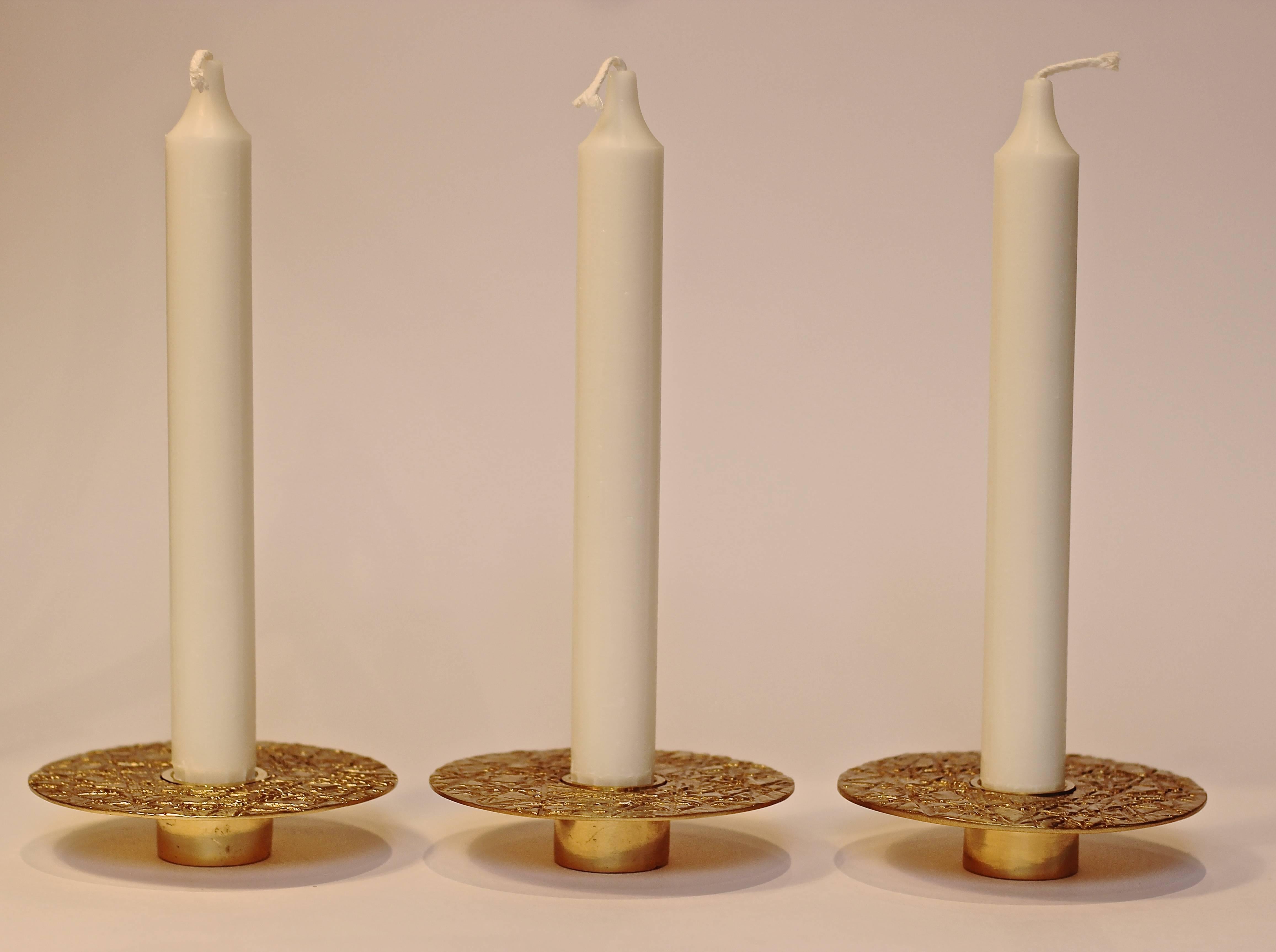 Each of those original brass candleholders is handmade individually. Cast and textured using very traditional techniques, they are polished to reveal the lustrous finish of this beautiful material.

Slight variations in the patina and polished