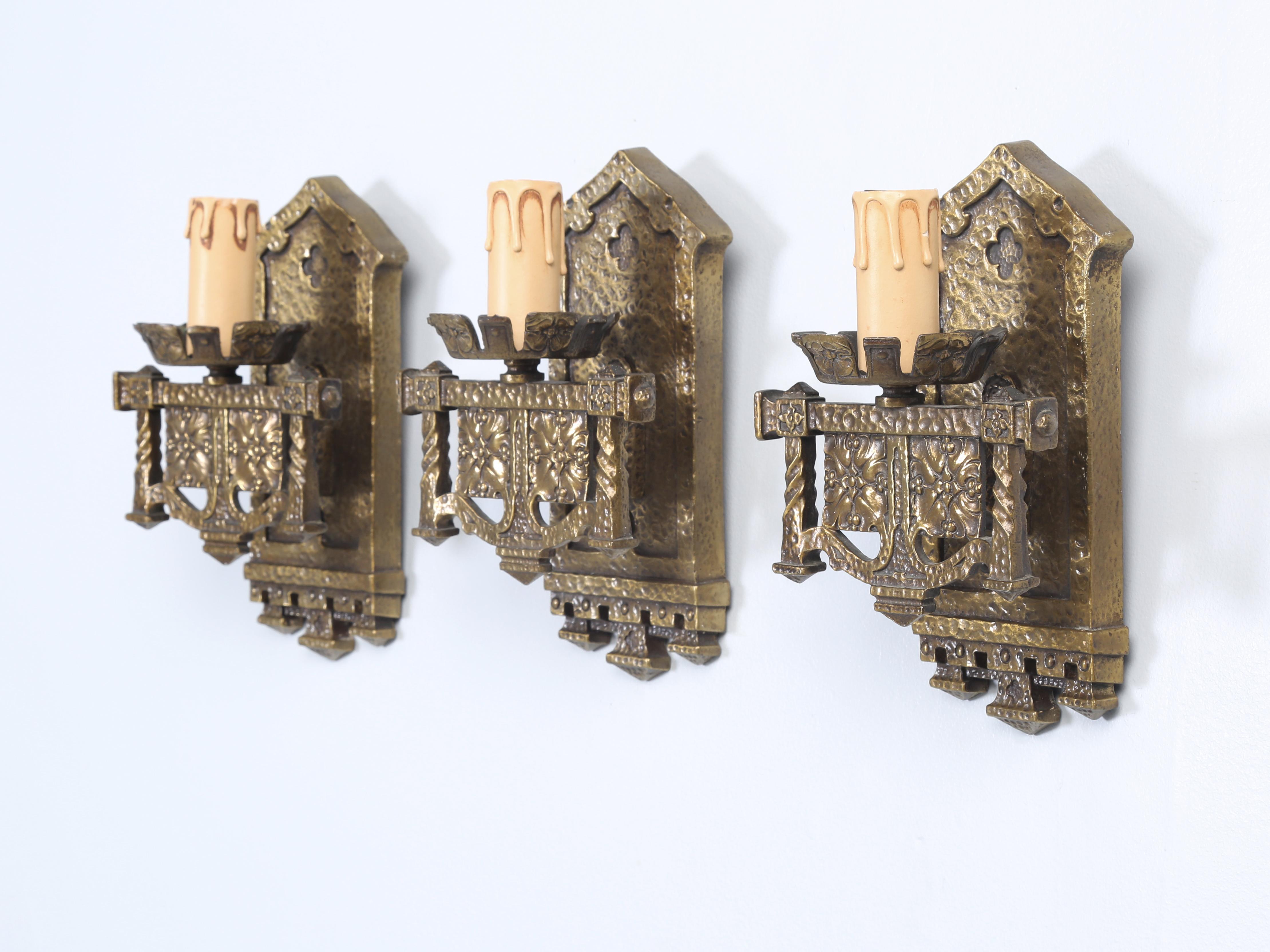 Set of (3) very heavy hand-made solid brass sconces that were removed from The John Rogerson Montgomery House, which was designed by noted architect Howard Van Doren Shaw in Glencoe, Illinois. The home is considered to be a significant example of