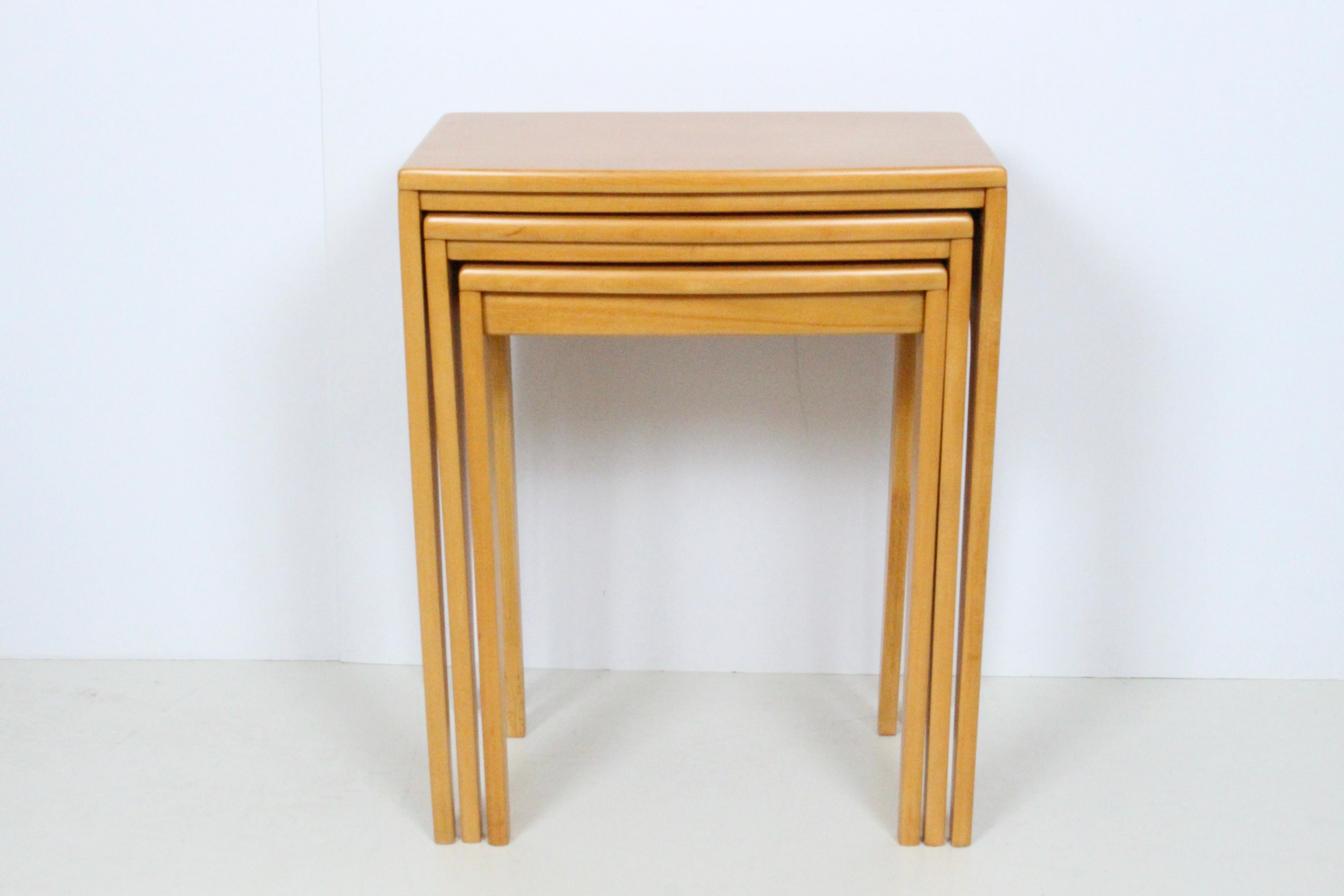 Set of three solid maple nesting tables in the style of Heywood Wakefield. Featuring a neutral, narrow rectangular form, smooth rounded face small footprint overall. Versatile. Compact. Sturdy. Measurements: Outside (25.75H x 21Wx 14D) Middle (24H x