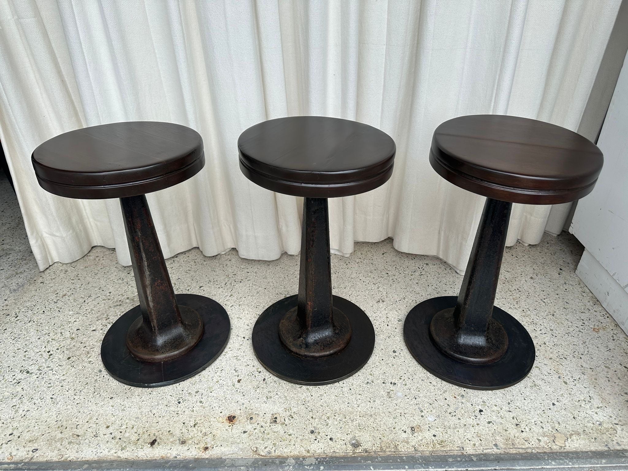 Estos TRES (3) taburetes giran 360 grados y han recuperado su belleza original con asientos de madera oscura y pesadas bases de hierro fundido.  MUY resistente y con un aspecto estupendo.  También se pueden utilizar como mesas auxiliares si se