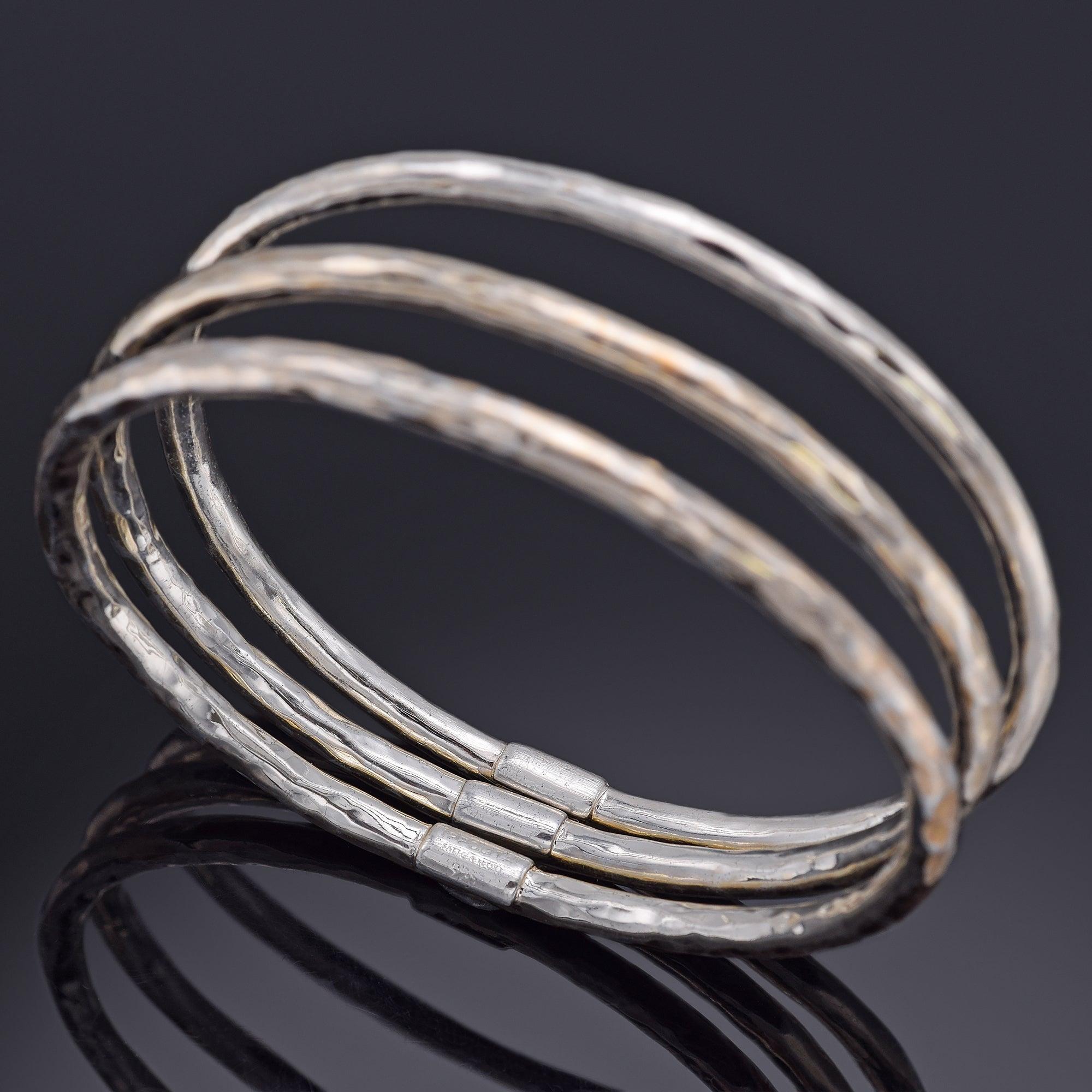 Le set de bracelets Fatto A Mano en argent sterling est un luxueux trio de bracelets fabriqués à la main, chacun mettant en valeur la texture martelée caractéristique de la marque. Ces bracelets peuvent être portés seuls pour un look minimaliste ou