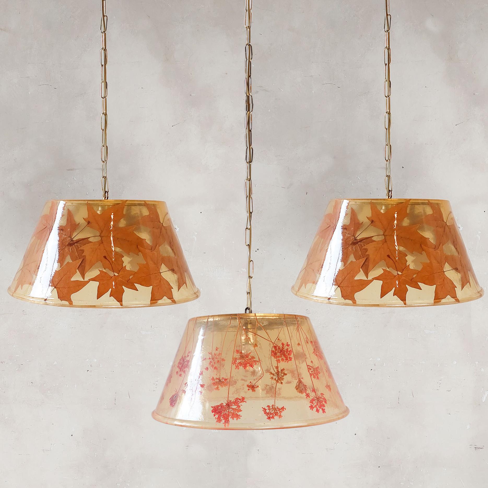 Set of 3 Italian 70s hanging lamps in the style of Gabriella Crespi. The shades are made of synthetic resin with leaves incorporated into two of them and dried flowers in the third.

Dimensions: Ø 42 cm x height 20 cm plus 95 cm cord