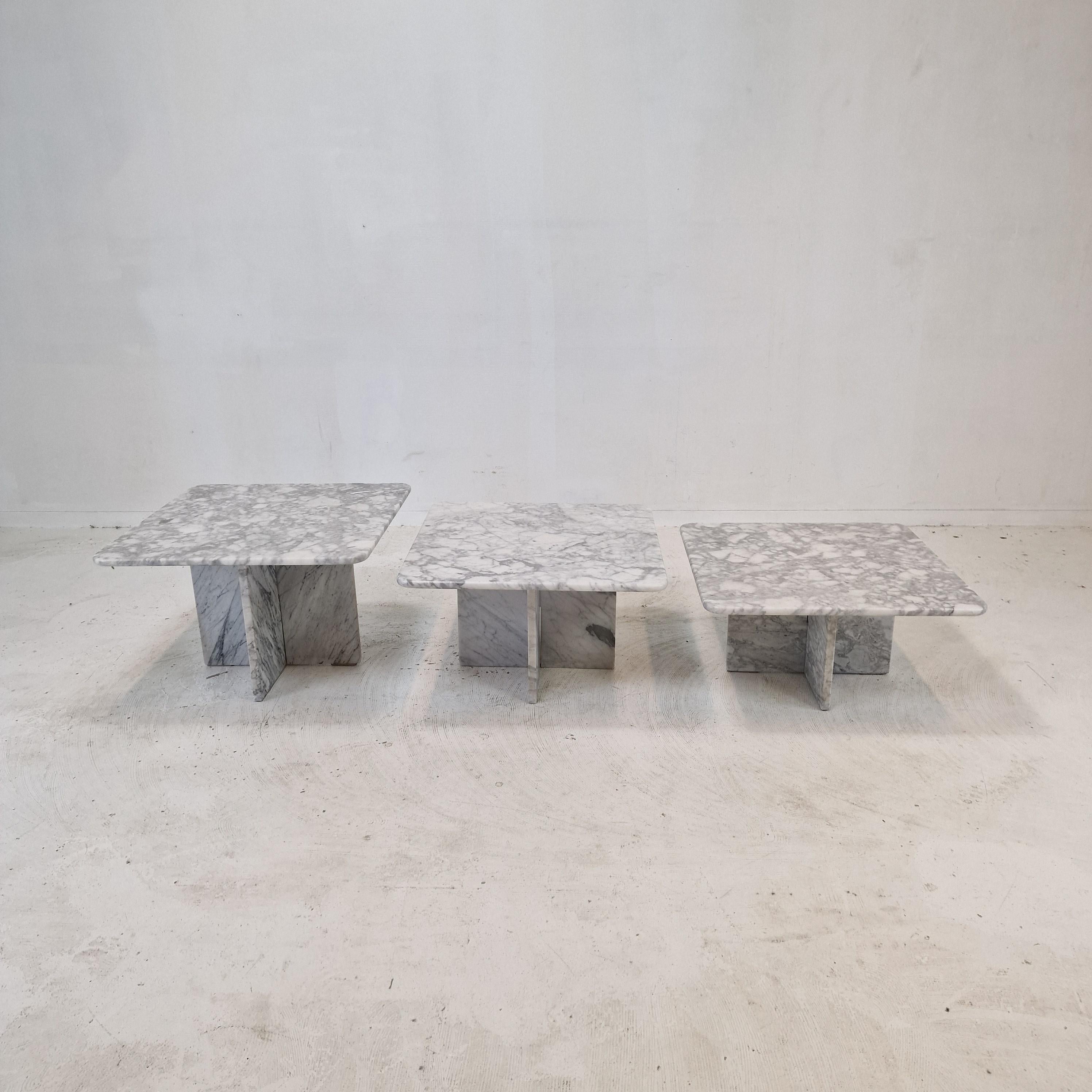 Stunning set of 3 Italian coffee or side tables, handcrafted out of Bianco Carrara Marble. 
They can be used inside or outside the house.

The tables all have a different height so they fit under each other. 

The plate and the base are made of
