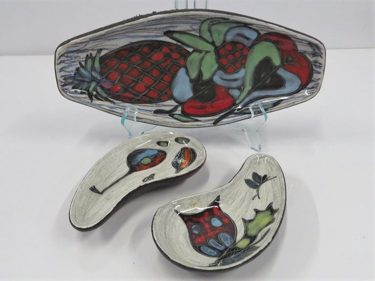Italian Trio of small Amorphic Ceramic Vessels clad with colored Leather. Colorful hand painted decoration of Fruits (signed Russo), Mandolin and an Owl and different color leather backing, burgundy red, navy blue and black similar to San Marino