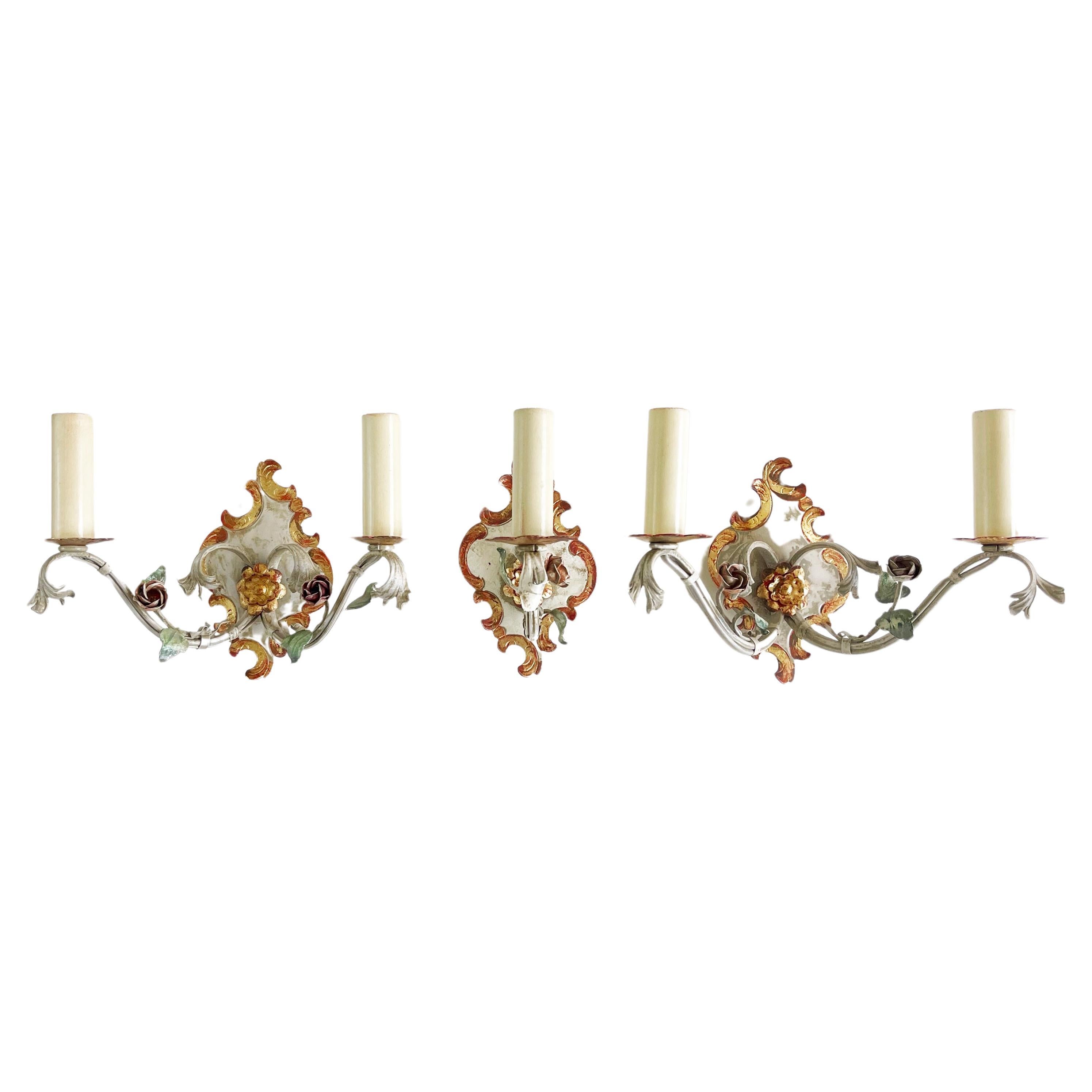 1960s sconces, made in Italy – a typical 1960s Italian Toleware design, hand crafted and
the leaves and roses hand forged.
A set of 3 wall lights: 2 of them two-armed, 1 one-armed, all with beautifully detailed decoration.
Elegant gilt wrought