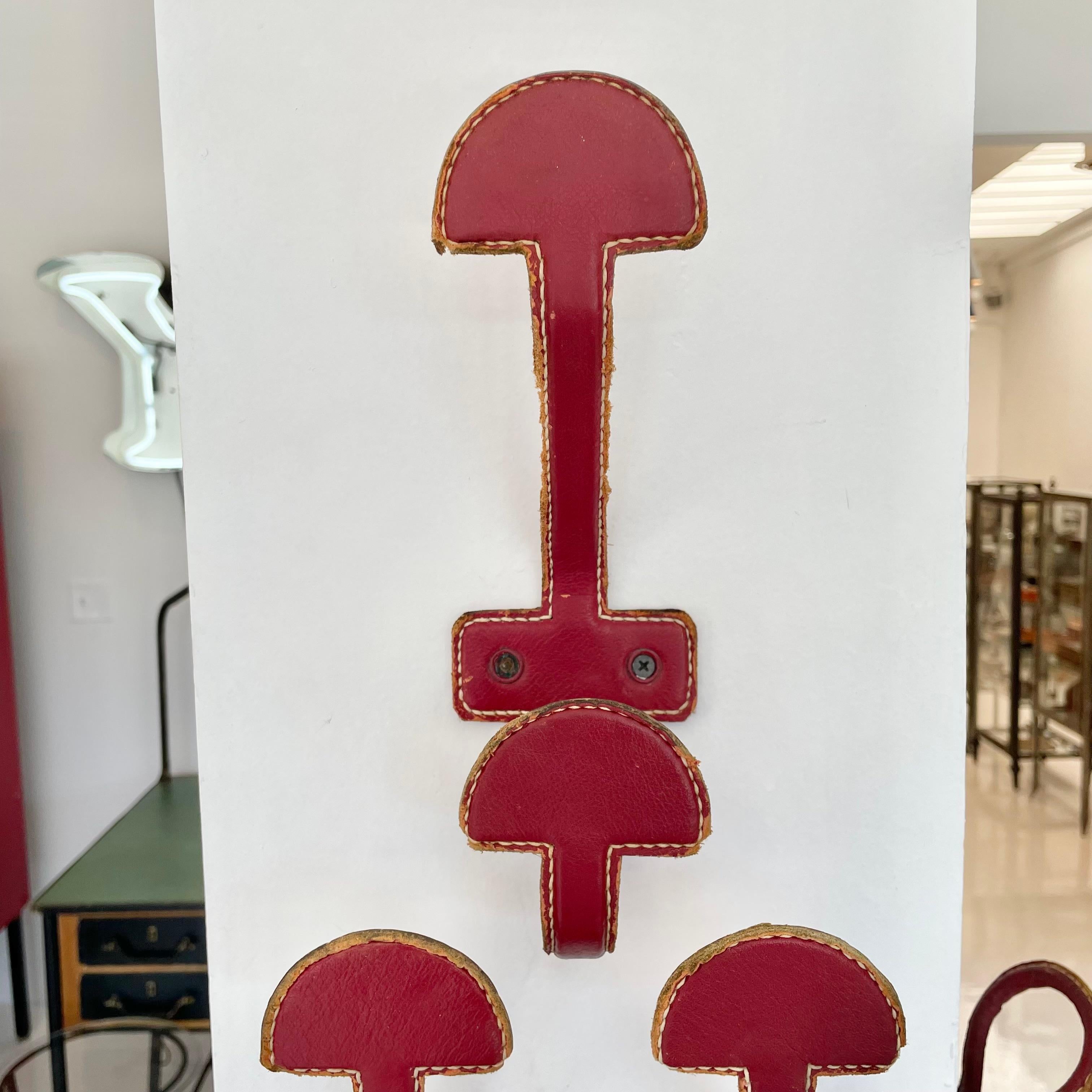 Set of 3 Jacques Adnet Red Leather Coat Hooks, 1950s France In Good Condition For Sale In Los Angeles, CA