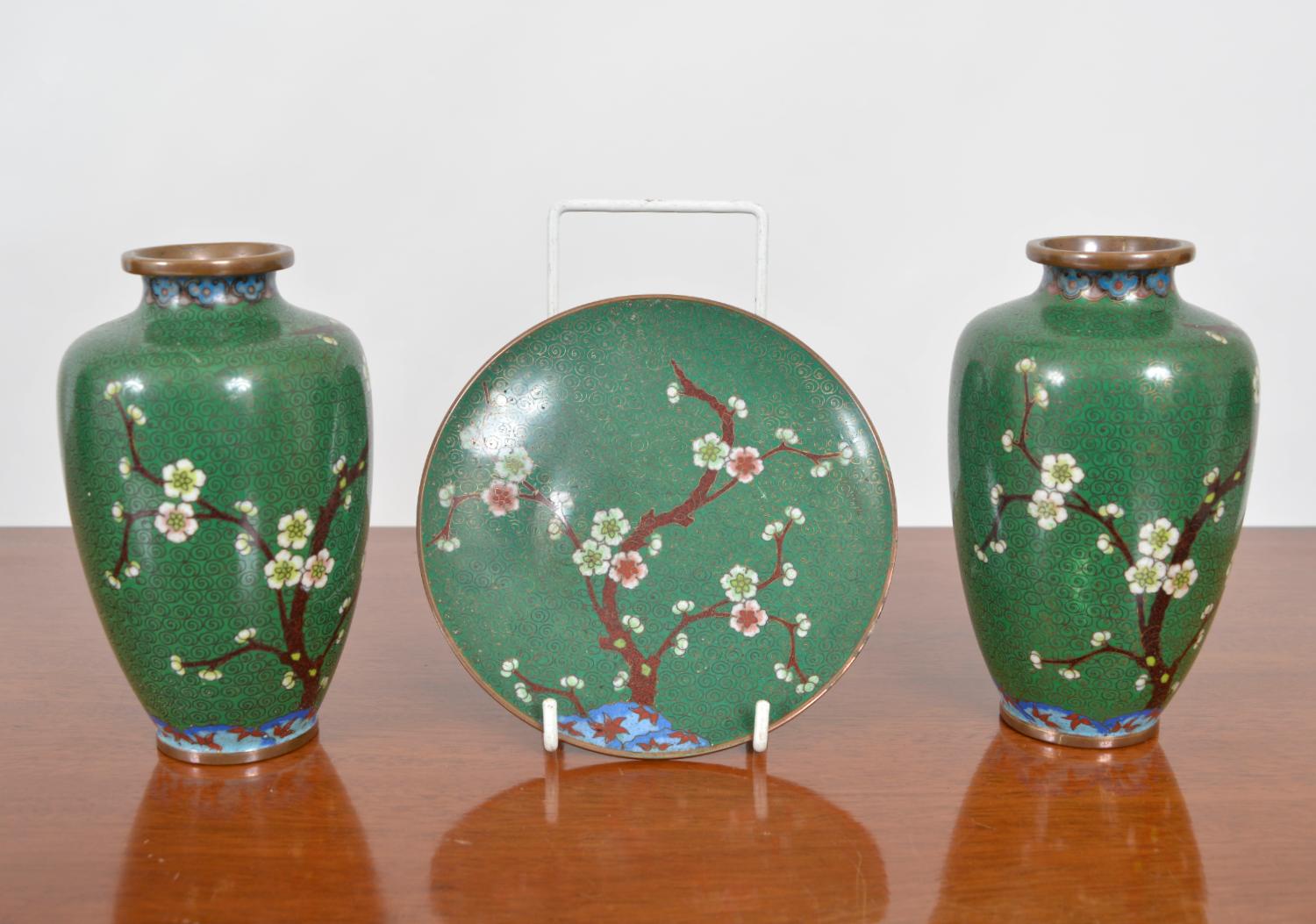 A very attractive matching set of early 20th century cloisonne vases and tray dish. Individual cloisons create decorative swirls of gold on a jade green background, while enamels of various colours, including white, green, and rust form the prunus