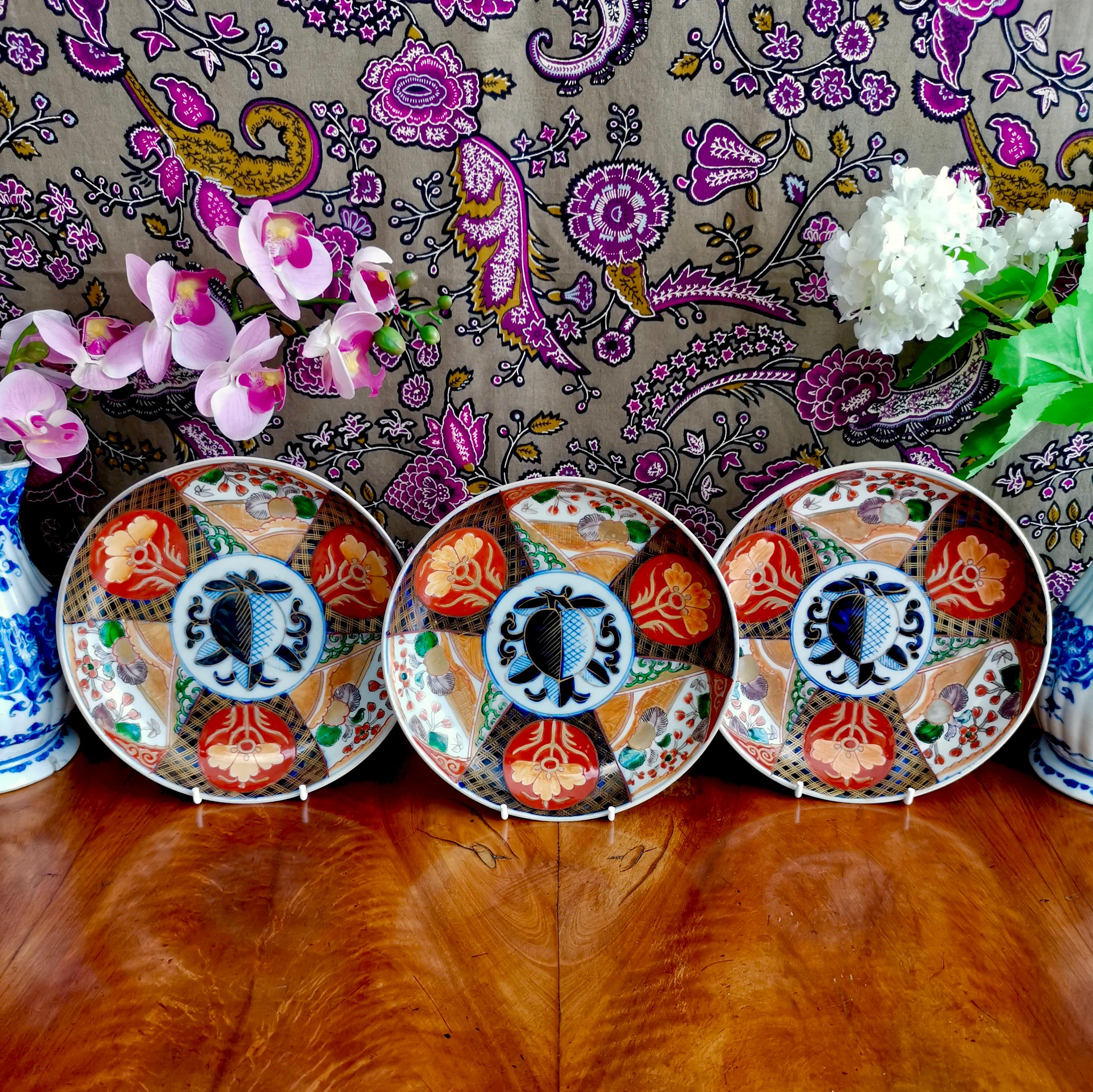 This is a set of three Japanese deep plates in the Imari style, most probably made in the late 19th or early 20th century, in the late Meiji period. The decoration is a 