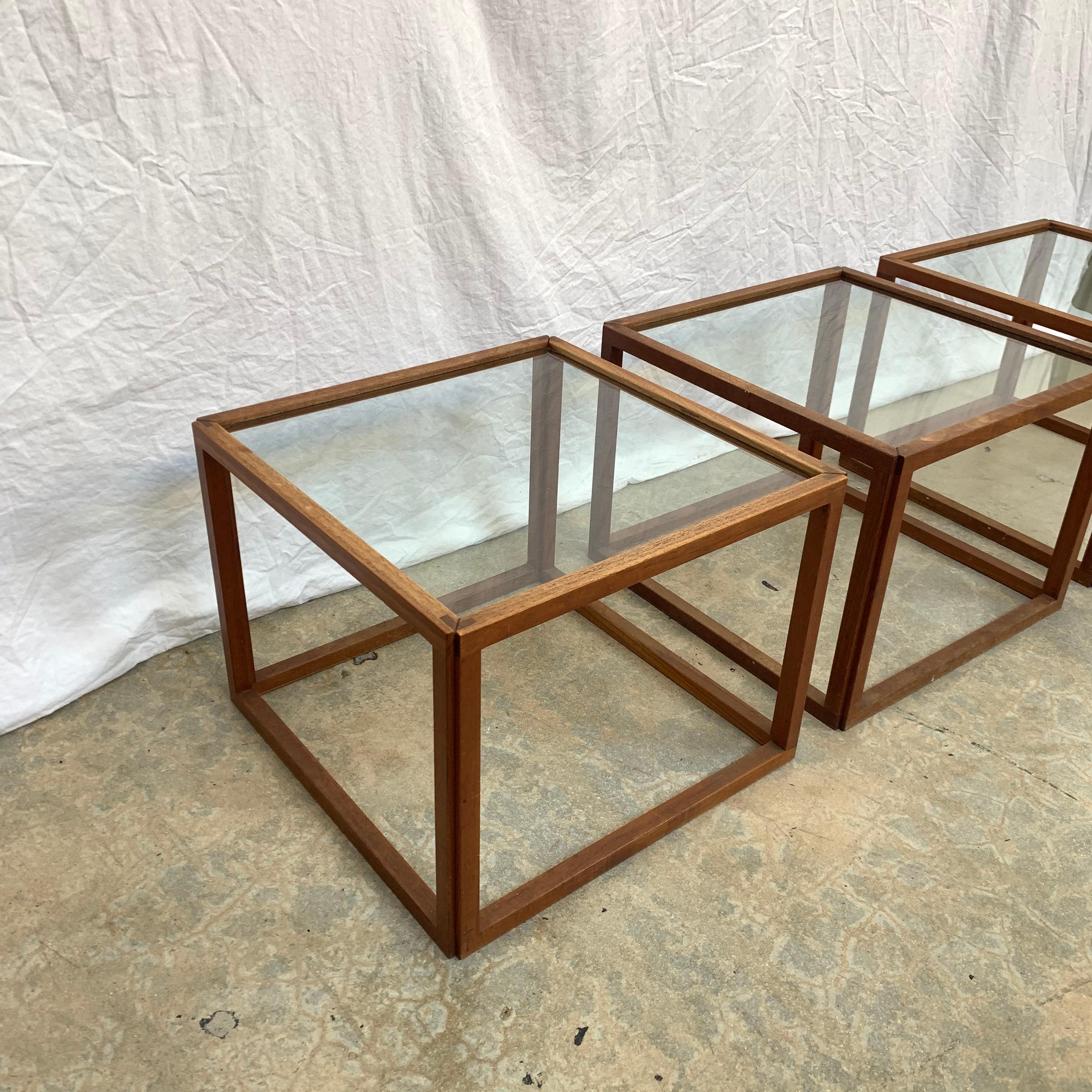Minimalist cube tables rendered in teak frames with an inset glass top designed by Kai Kristiansen, Denmark, 1950s.

Can be sold individually.