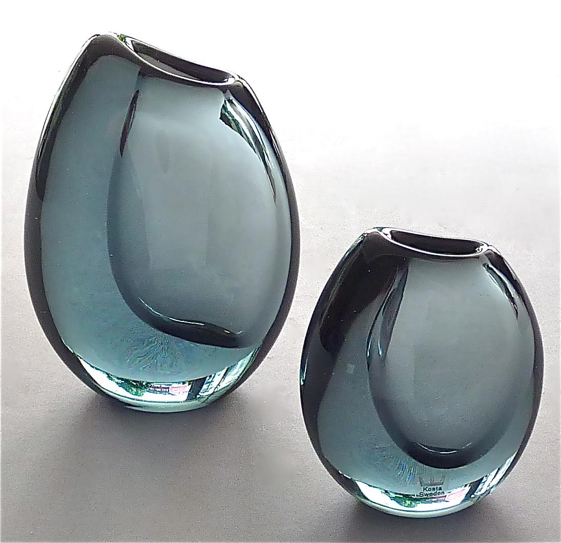 Gorgeous set of three Kosta organic shaped crystal glass vases in smokey grey to greyish blue color designed by Vicke Lindstrand for Kosta, Sweden around 1950-1960s.
The thick walled and large organic shape vase is 16 cm / 6.30 inches tall, 12 cm /