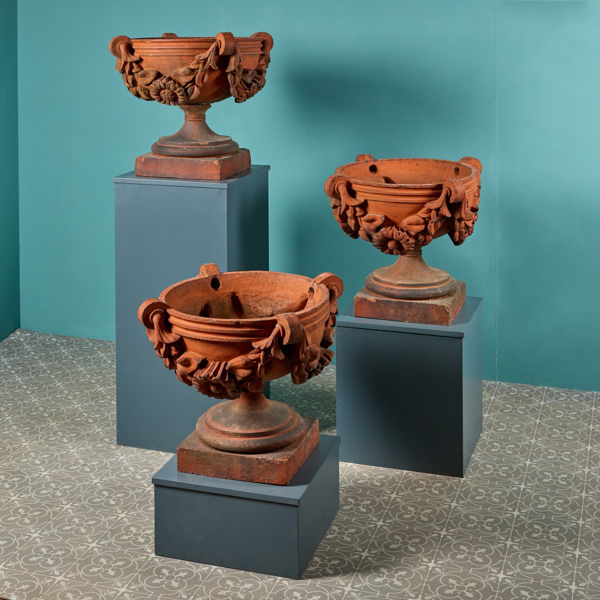 An impressive set of three large scale antique terracotta jardinieres or vases in the classical style, perfect for use as statuary or planters in a garden. Dating from 19th century England, these antique garden urns have stood the test of time for