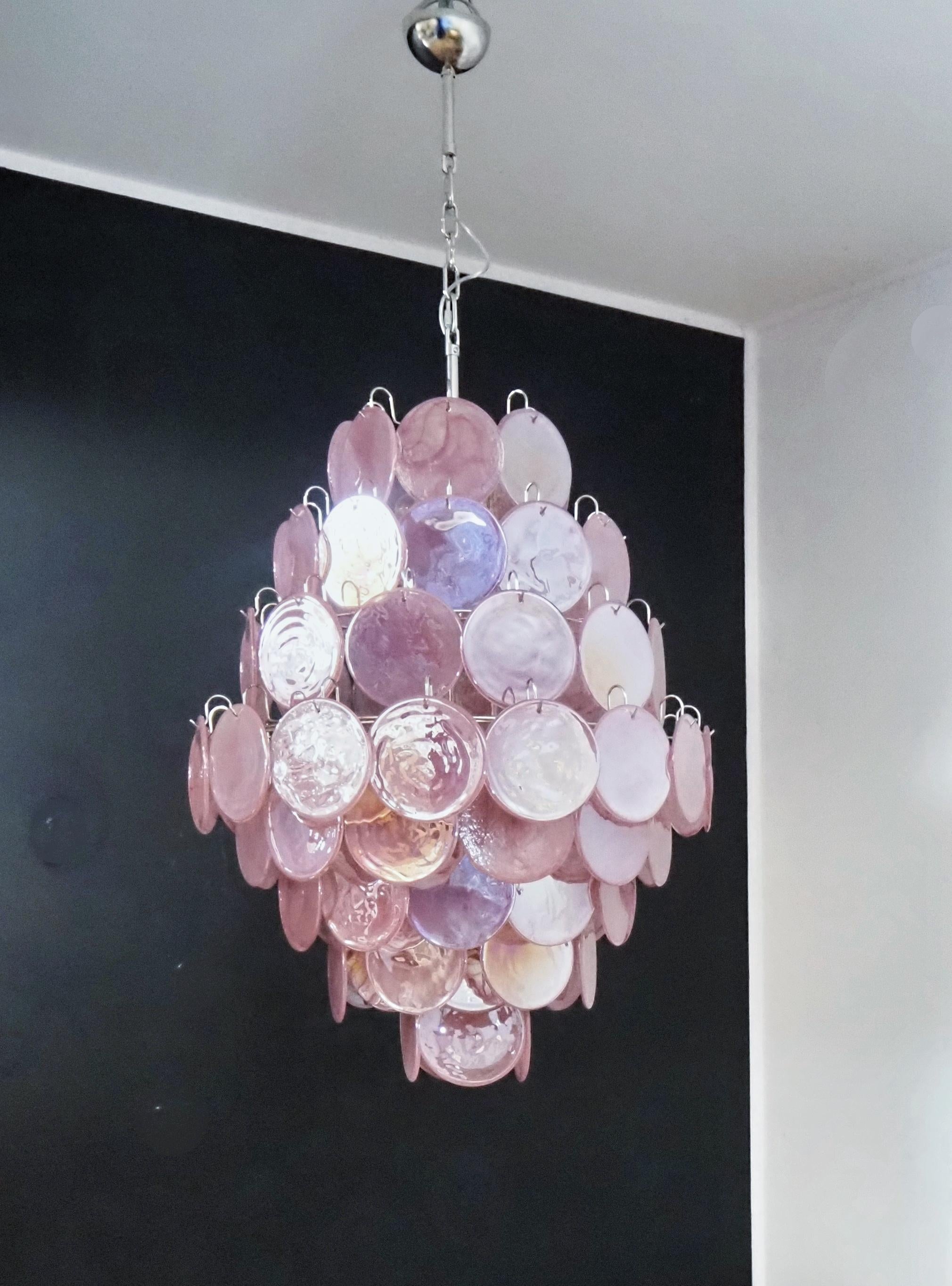 Set di tre (3) lampadari eclettici in vetro di Murano colorato in rosa. Ogni lampadario ha 87 dischi rosa in stile Vistosi. I dischi di vetro hanno un bellissimo motivo a volute in diverse tonalità di rosa. Gli occhiali sono appesi a una montatura
