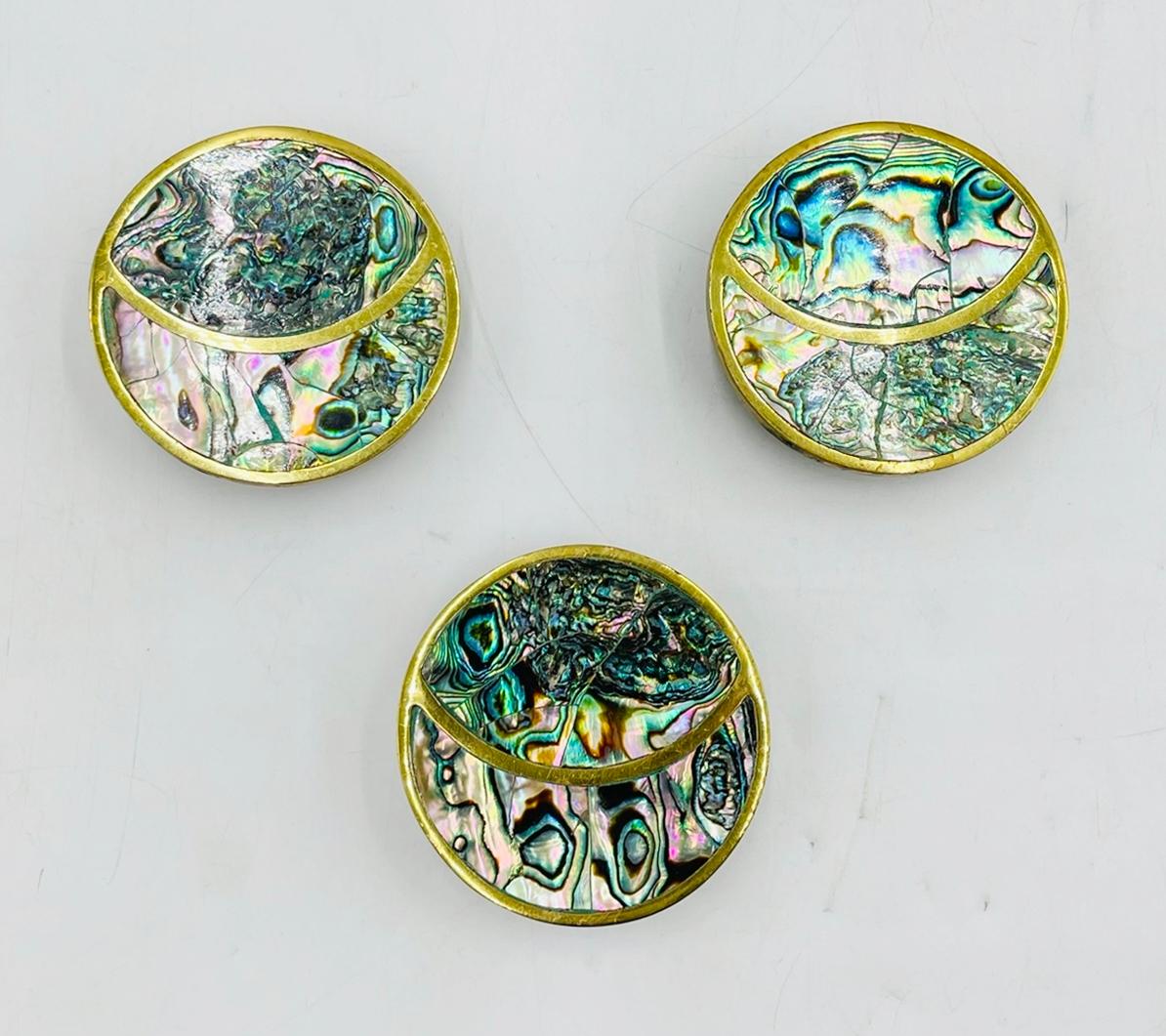 Rehaussez l'élégance de vos portes avec cet exquis ensemble de 3 grandes poignées de porte en laiton et coquille d'haliotide, conçu et fabriqué dans les années 1950 au Mexique (Distrito Federal).  par Peñoles. 
Les pièces sont fabriquées en laiton