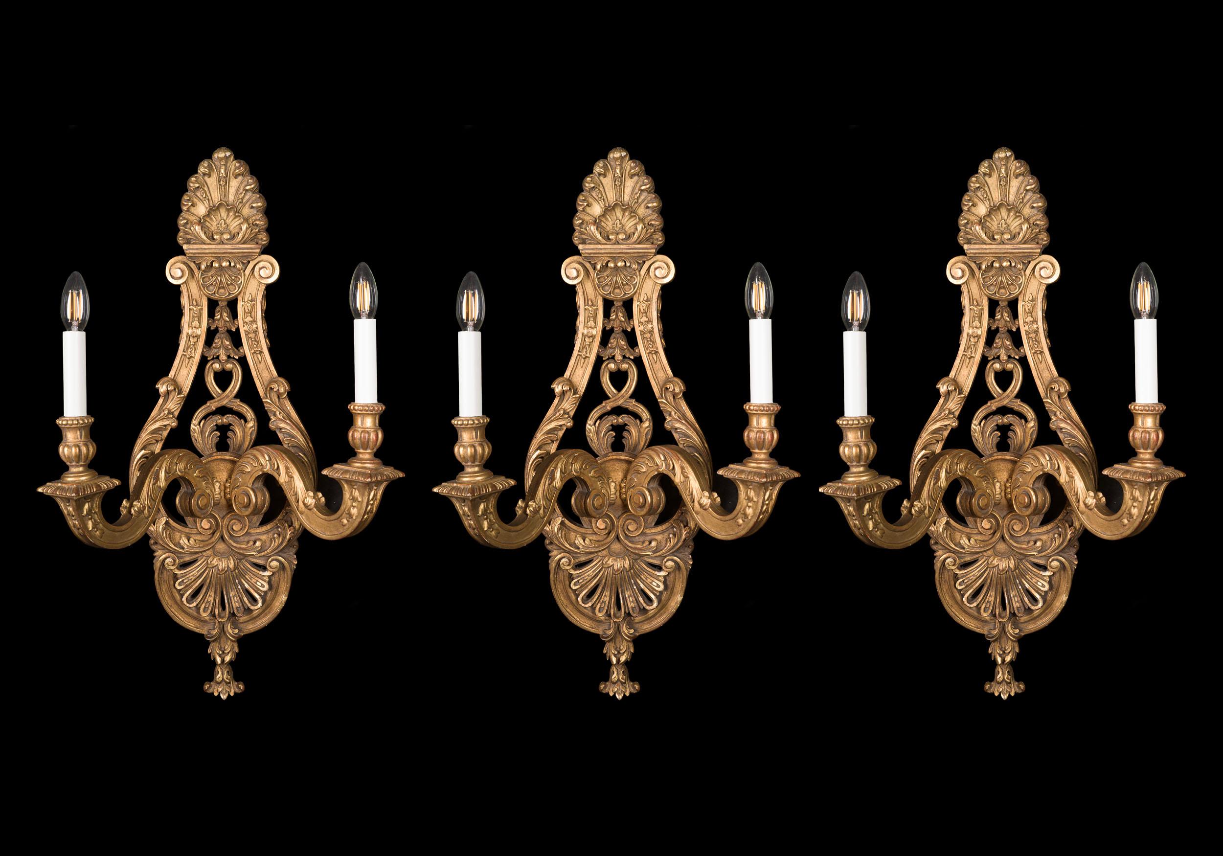 Juego muy fino de tres grandes apliques de madera dorada de estilo Régence, ornamentados con florituras foliadas y palmetas, y ramas gemelas de cuello de cisne.

Francés, principios del siglo XX.