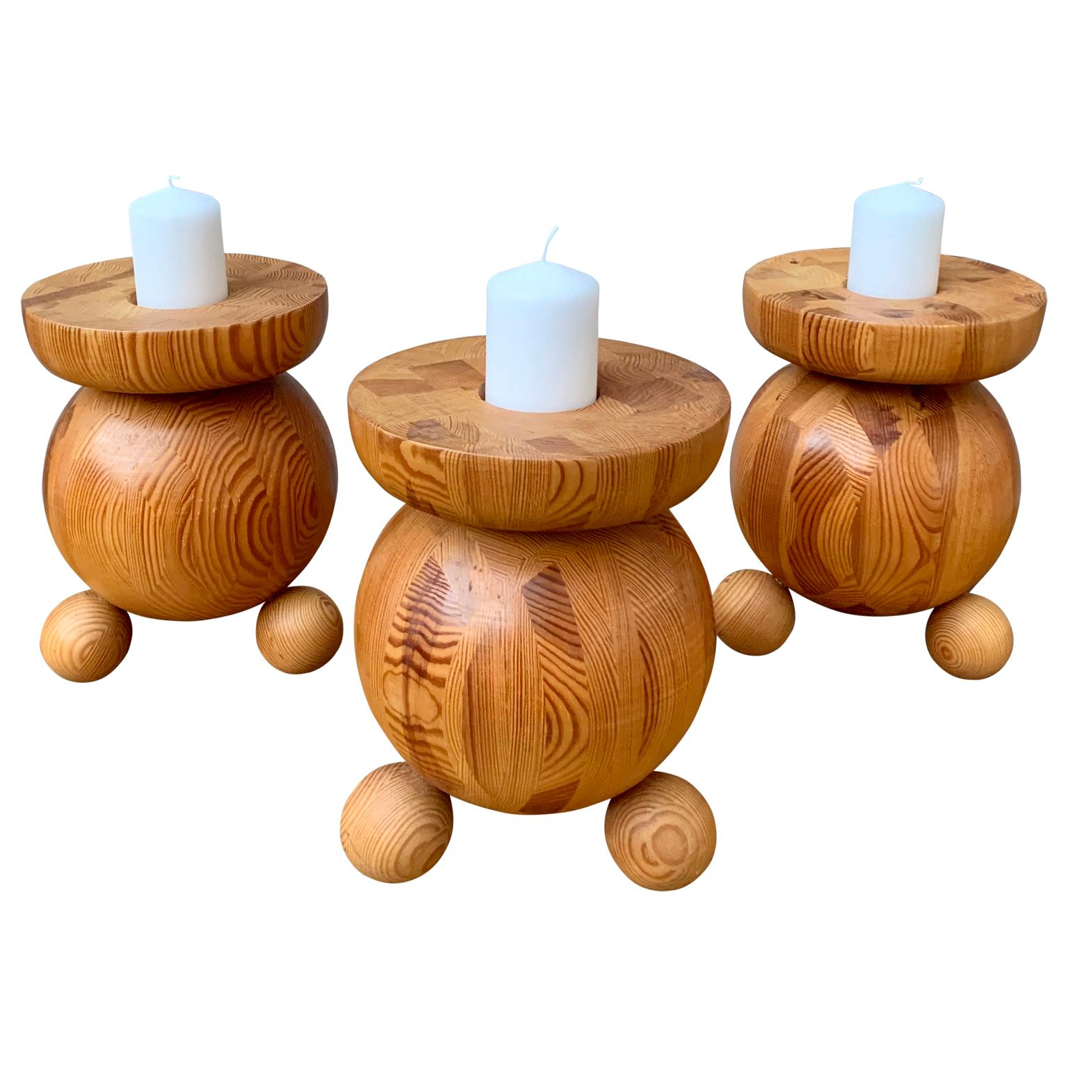 A set of 3 Swedish very large wooden candleholders from the 1970s. The massive candlesticks are made in thick pine wood and each supports one 2 1/2 inch thick candle (6.5 centimeter diameter).