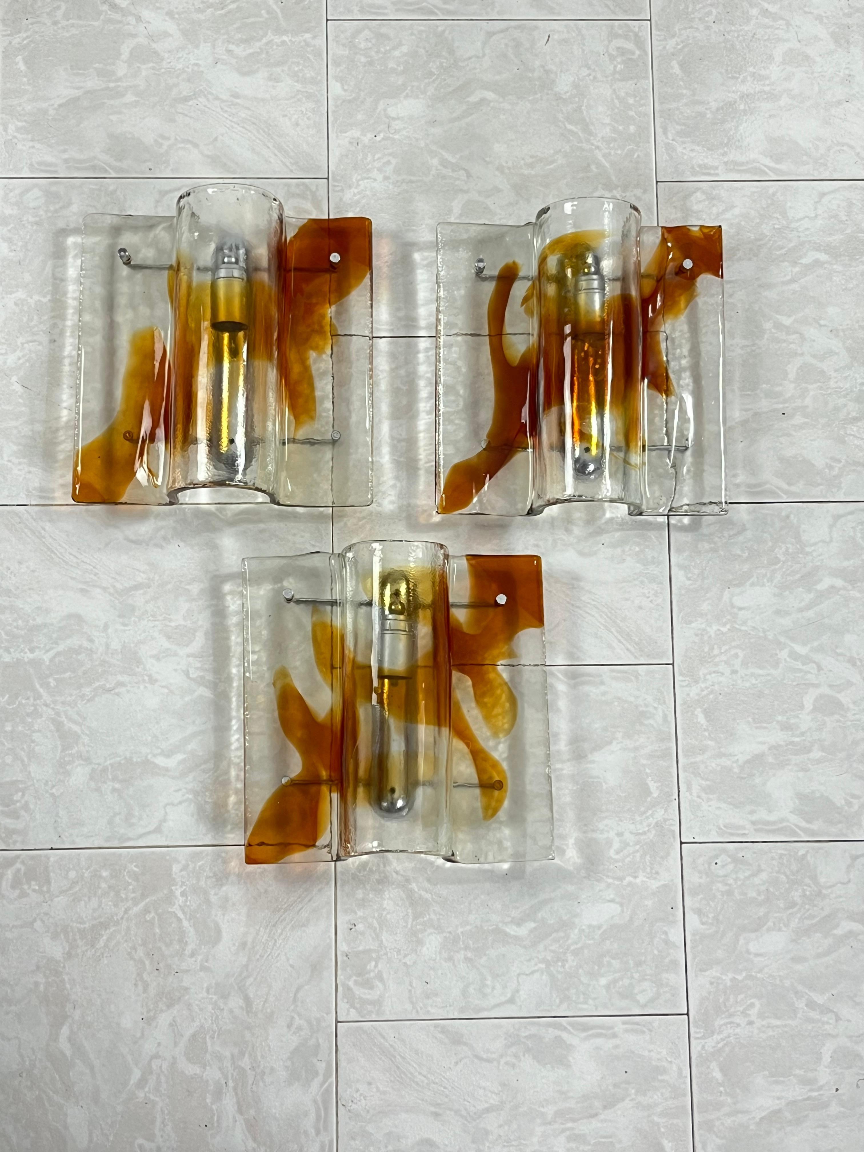 Juego de 3 grandes apliques de cristal de Murano de mediados de siglo, años 60
Estructuras metálicas, lámparas E27, buen estado.
Elaboración artesanal de los maestros de Murano, evidenciada por las pequeñas diferencias entre los vasos y las pequeñas