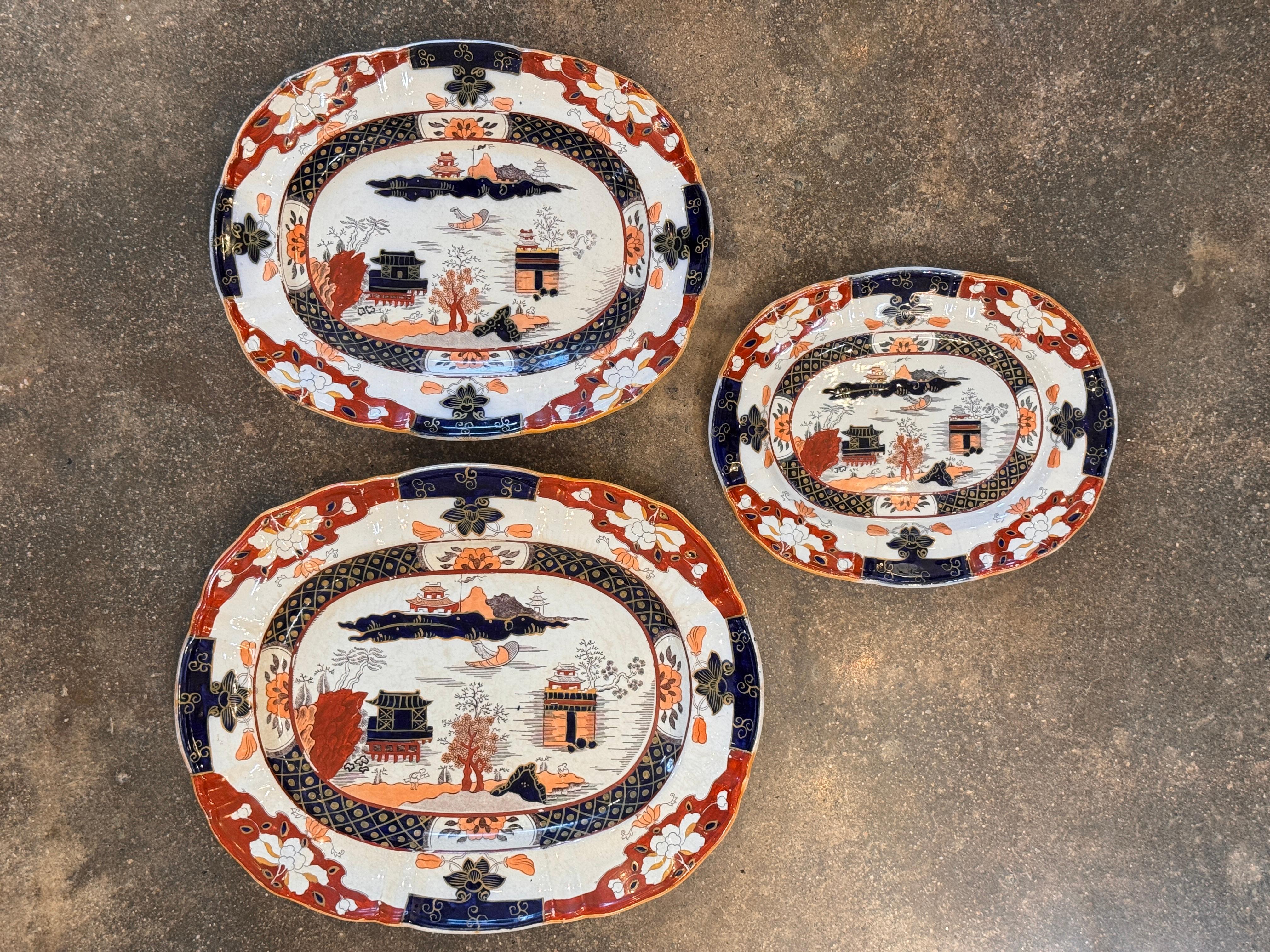 Set di tre piatti inglesi Mason's Patent Ironstone China in un'audace tavolozza Imari. Ognuno di essi presenta l'iconico motivo del paesaggio orientale con vivaci accenti cobalto, ruggine e dorati. Offerto come set completo abbinato.