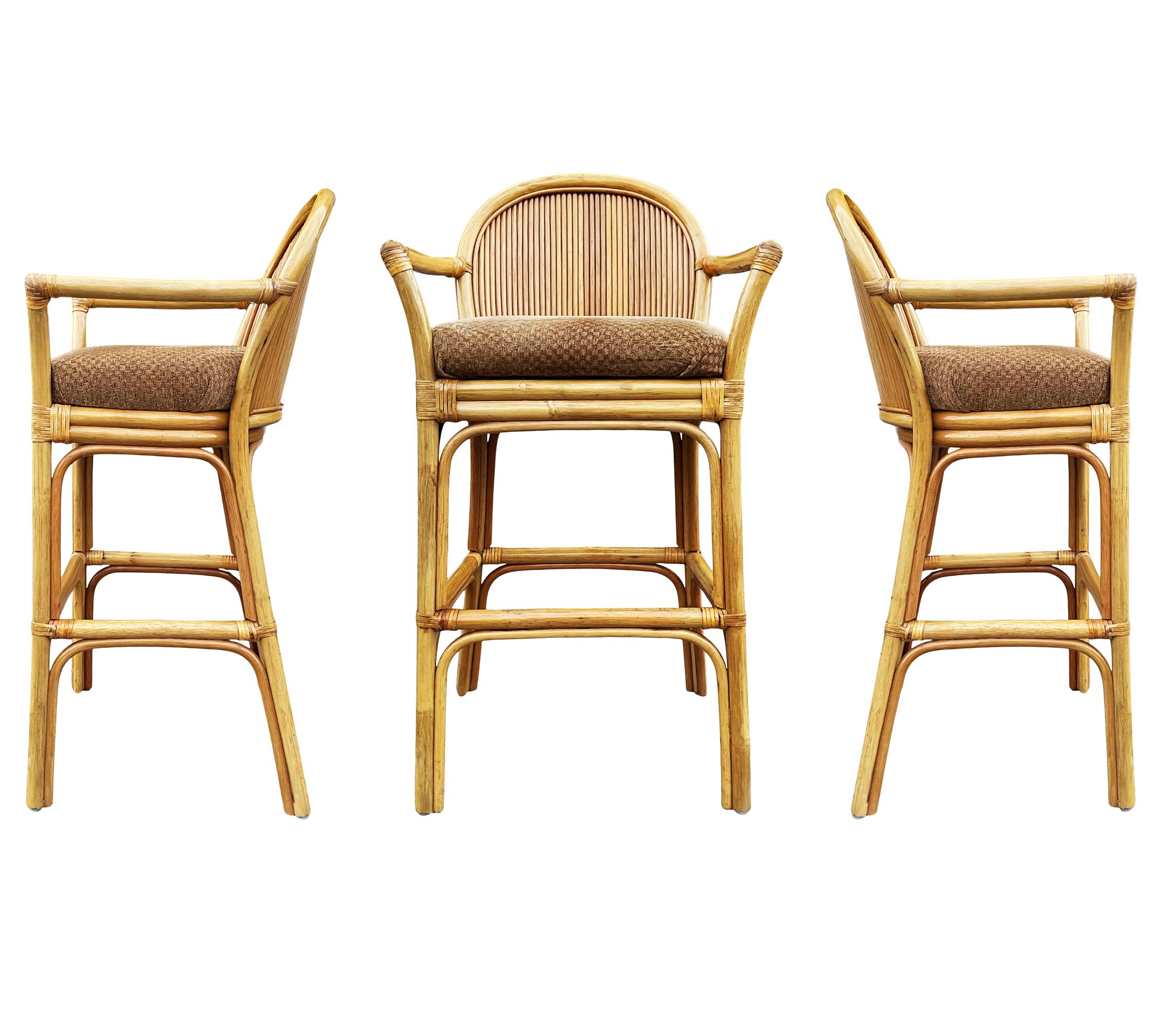 A vintage set of rattan / bamboo barstools circa mid 1970's. These bar stools feature rattan framing with upholstered seats. Fabric is original so recovering is recommended.