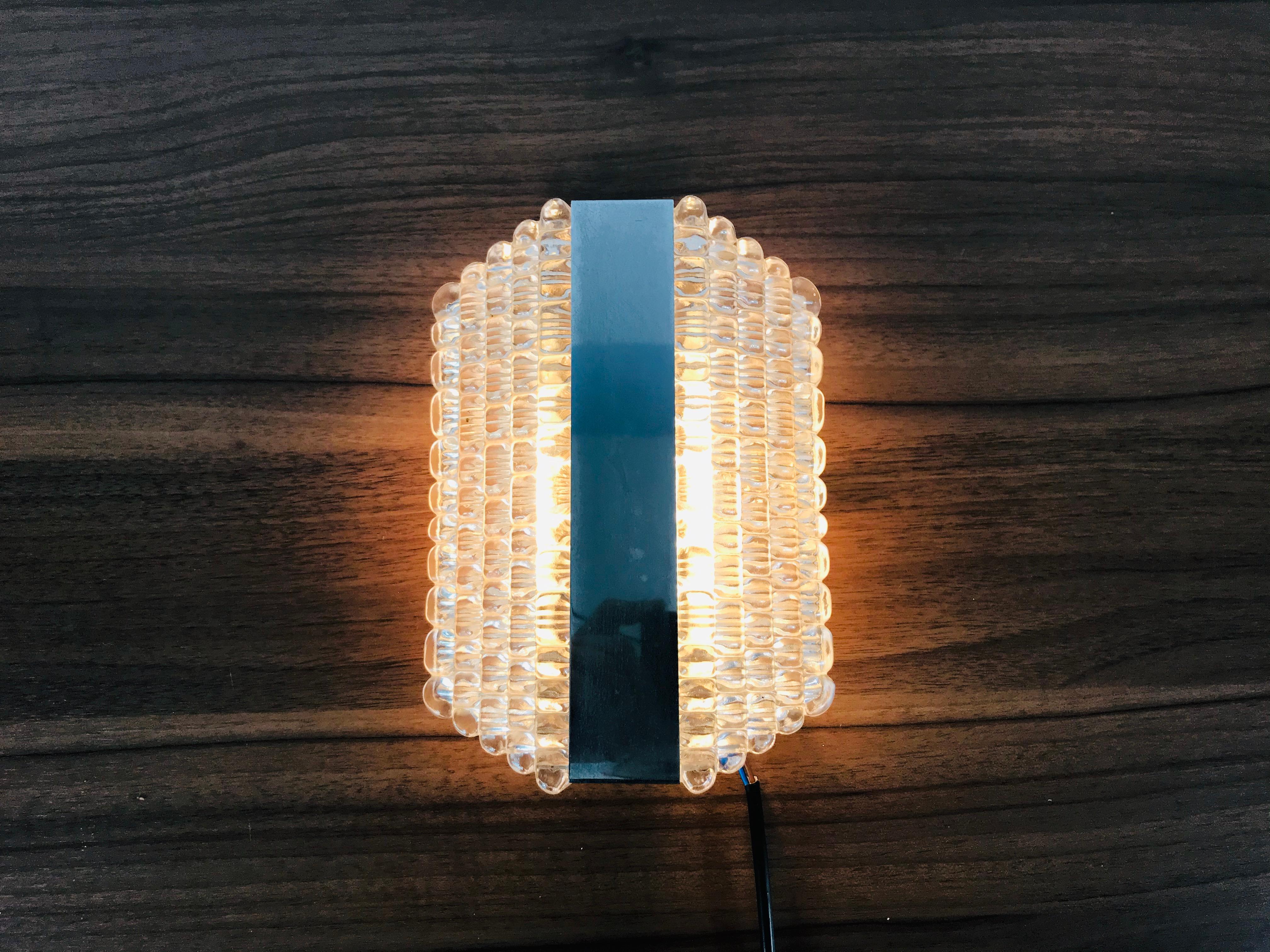 A set of midcentury wall lamps by Kaiser made in Germany in the 1960s. It is fascinating with its Space Age design and unique glass shades. The body of the light is made of full metal. 

  
  