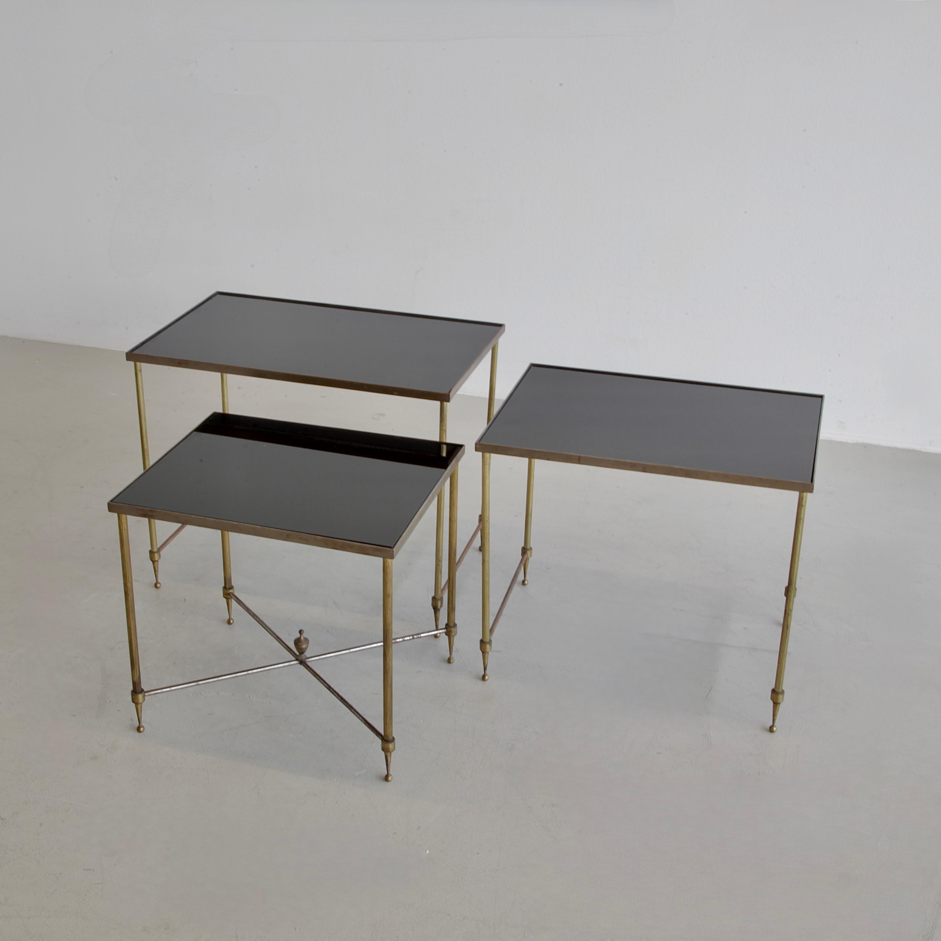 Satz von drei Beistelltischen. Frankreich, 1960er Jahre.

Metallrahmen mit kleinen Verzierungen und schwarz getönten Glasplatten. Die angegebene Größe bezieht sich auf das größte Exemplar des Sets. Bitte fragen Sie nach den anderen