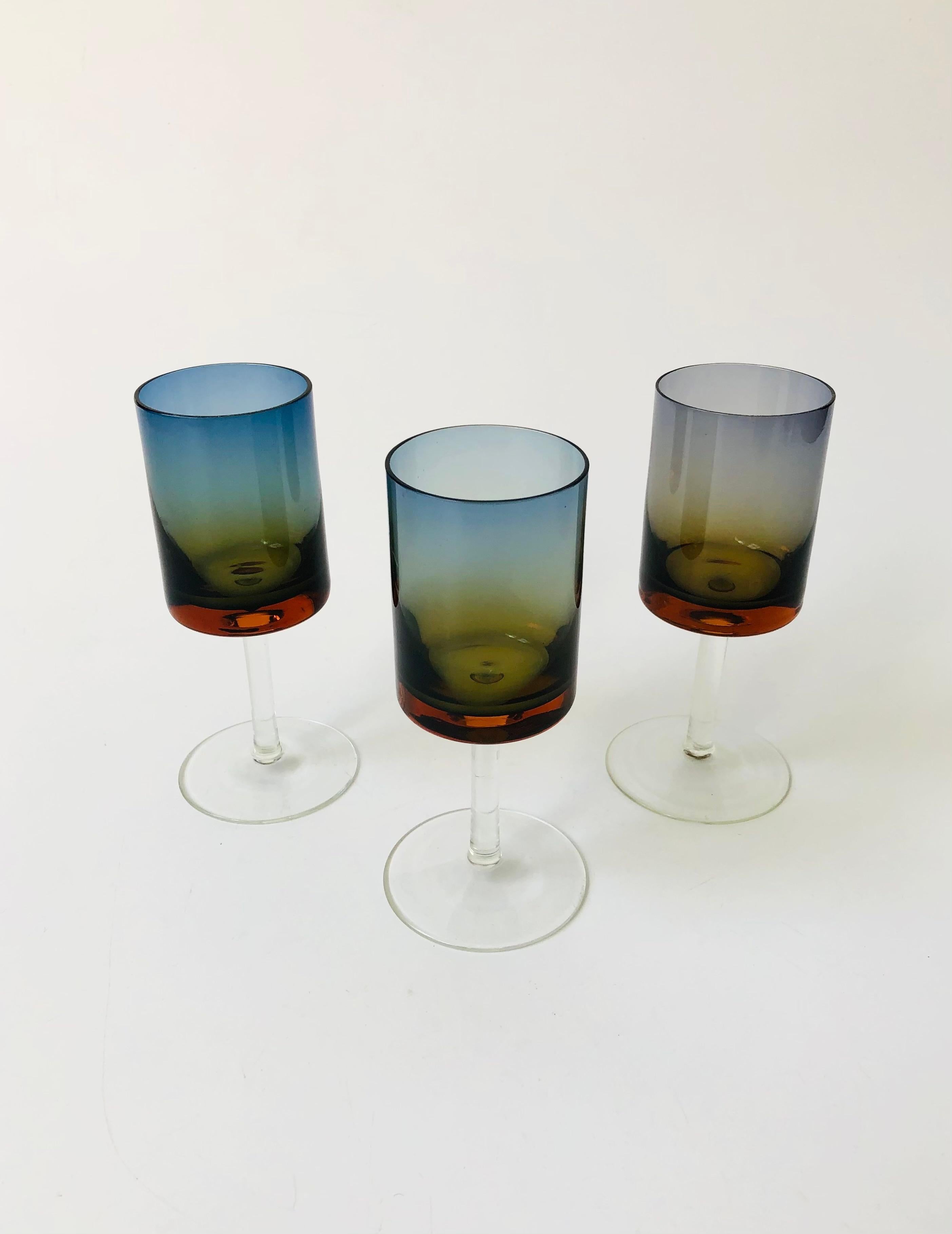 A set of 3 gorgeous rare mid century Blue Amberina stemmed glasses. Each glass has a cylindrical shape with a thin clear stem. Beautiful colouring to the tops fading from blue to amber. These are a smaller size than a wine glass and could be used