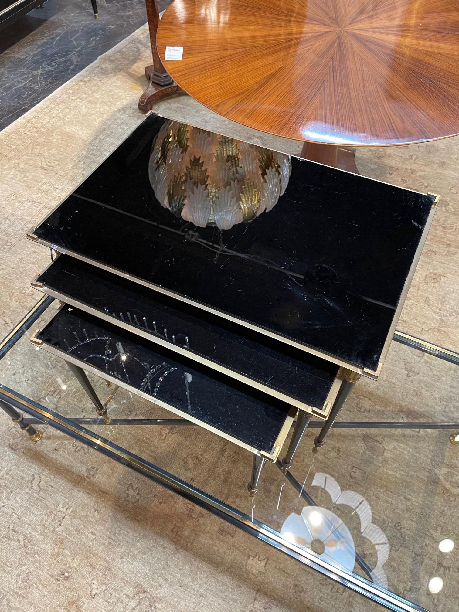 Elegant pair of 3 midcentury brass and black glass nesting tables. Very fine quality on these. Creates a Classic look!